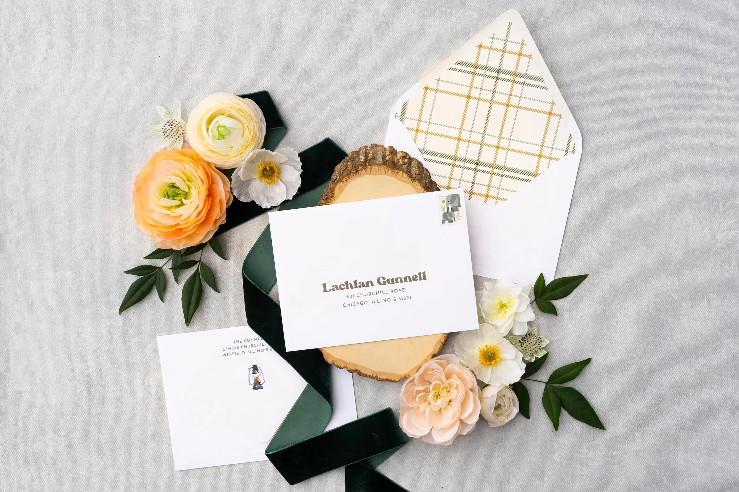 Rustic luxury first birthday invitation suite with plaid envelope liner, camping illustrations, twine accents, and whimsical “One Happy Camper” styling.