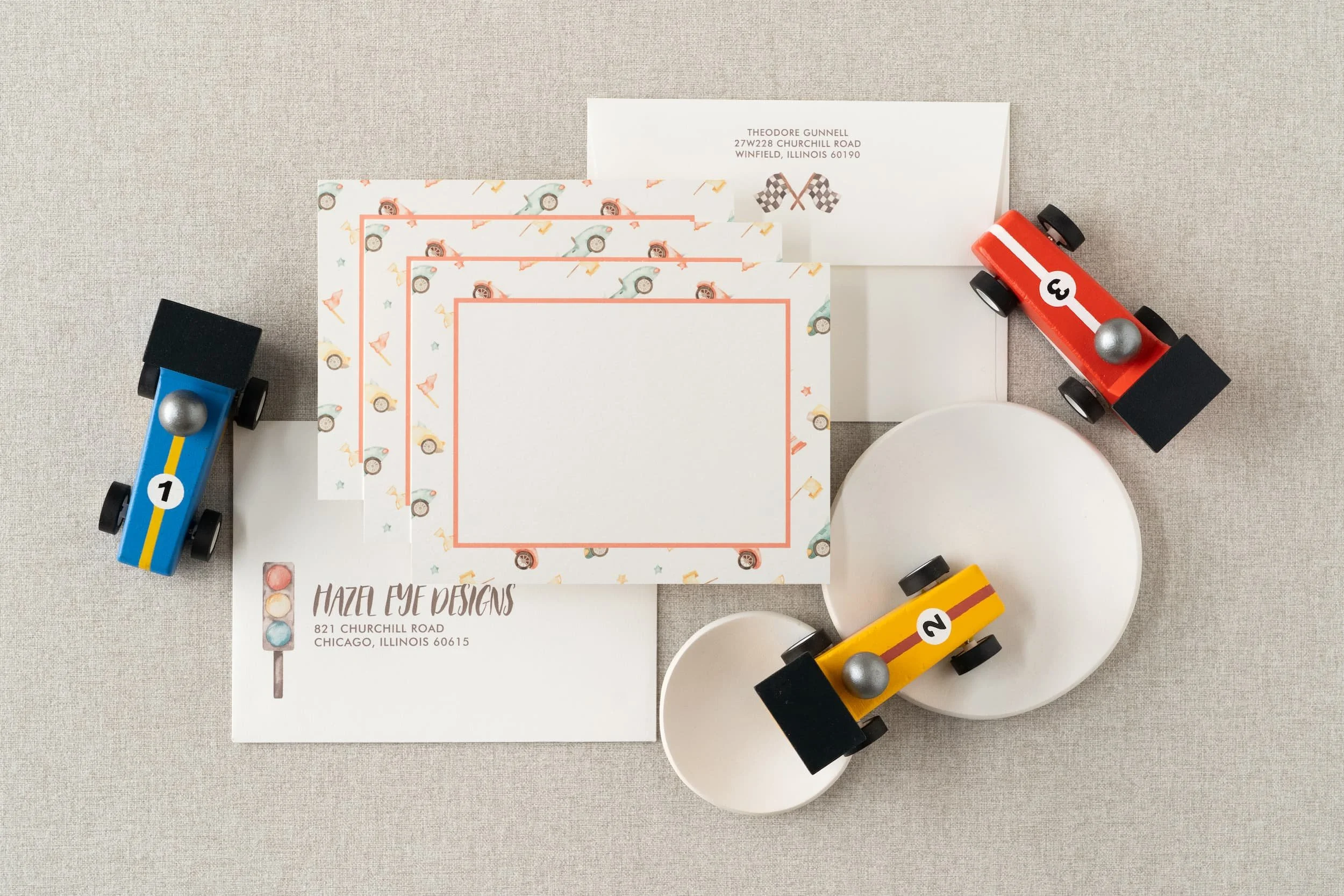 Race car-themed second birthday stationery suite with playful watercolor cars, checkered flag patterns, and motorsport-inspired paper details.