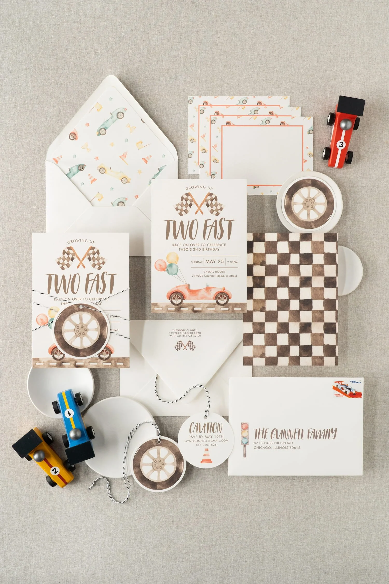 “Two Fast” race car birthday invitation suite for a two-year-old boy featuring watercolor race car illustrations, black-and-white check details, and vintage-inspired racing stamps.