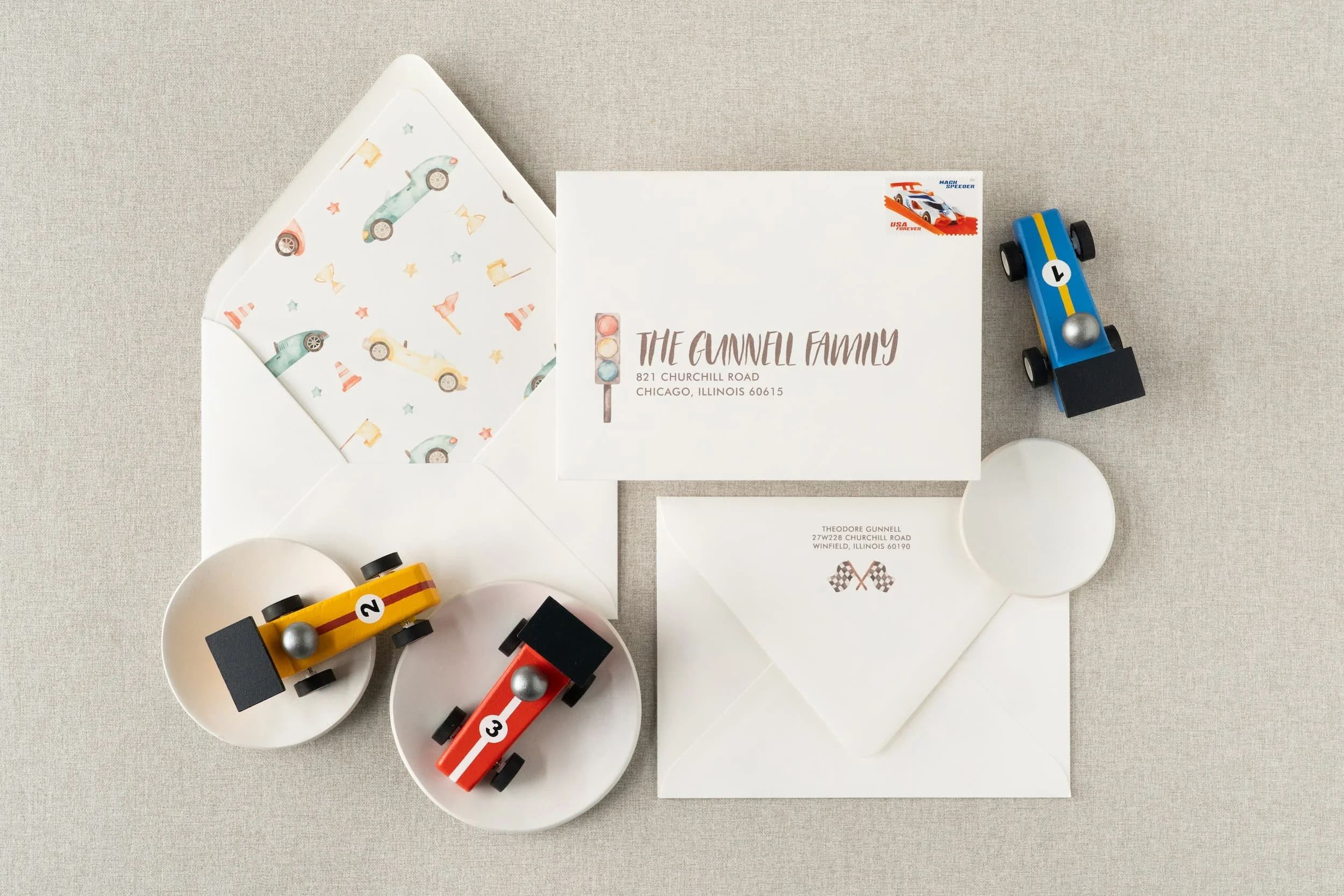 “Two Fast” race car birthday invitation suite for a two-year-old boy featuring watercolor race car illustrations, black-and-white check details, and vintage-inspired racing stamps.