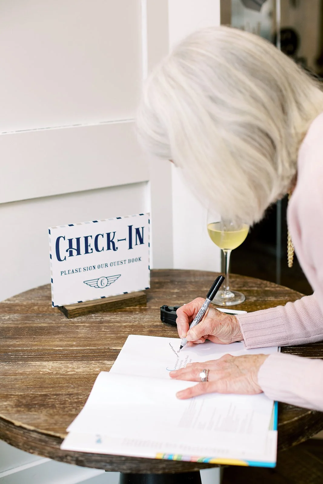 Baby shower guest book check-in featuring Oh, the Places You'll Go! by Dr. Seuss for guests to sign, styled as an airport-inspired check-in station celebrating the parents' love of travel.