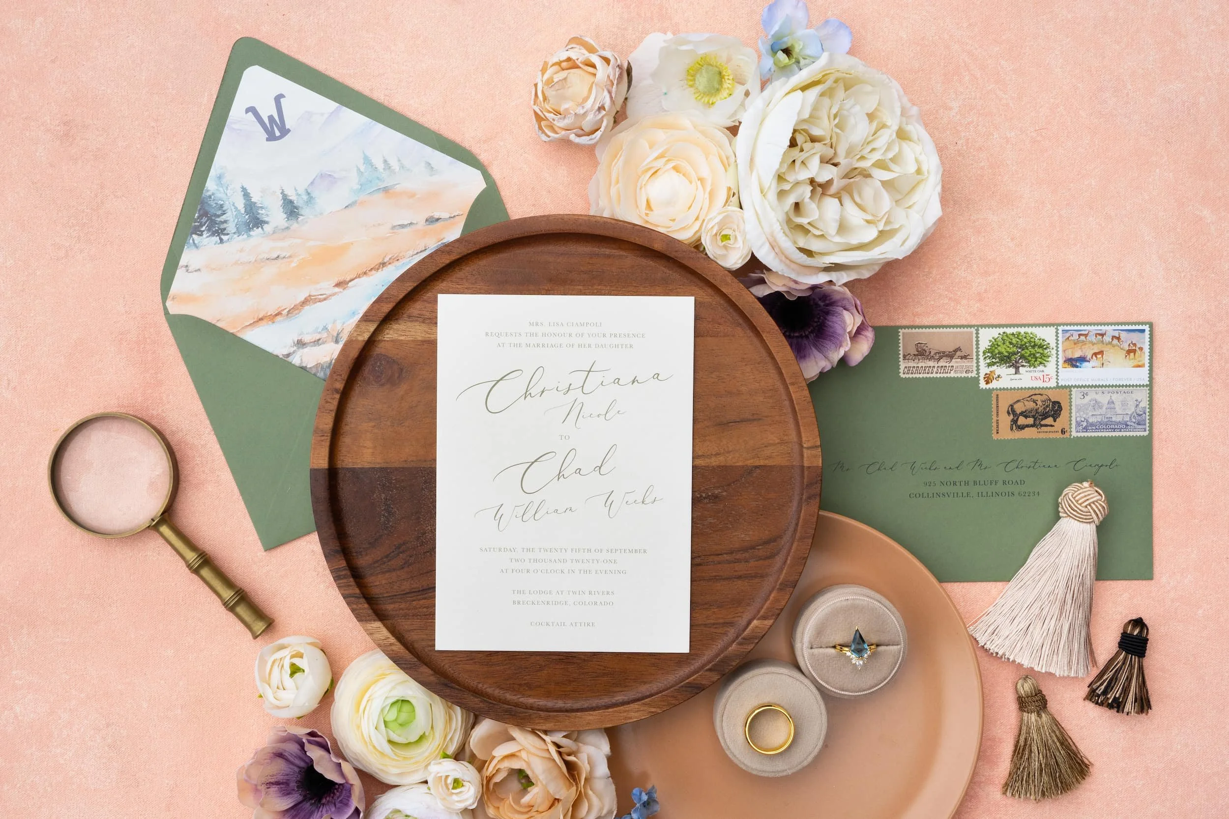 Close-up of a mountain-inspired wedding invitation with watercolor fall landscapes, modern calligraphy, and a soft peach and sage color palette inspired by luxury ranch weddings.