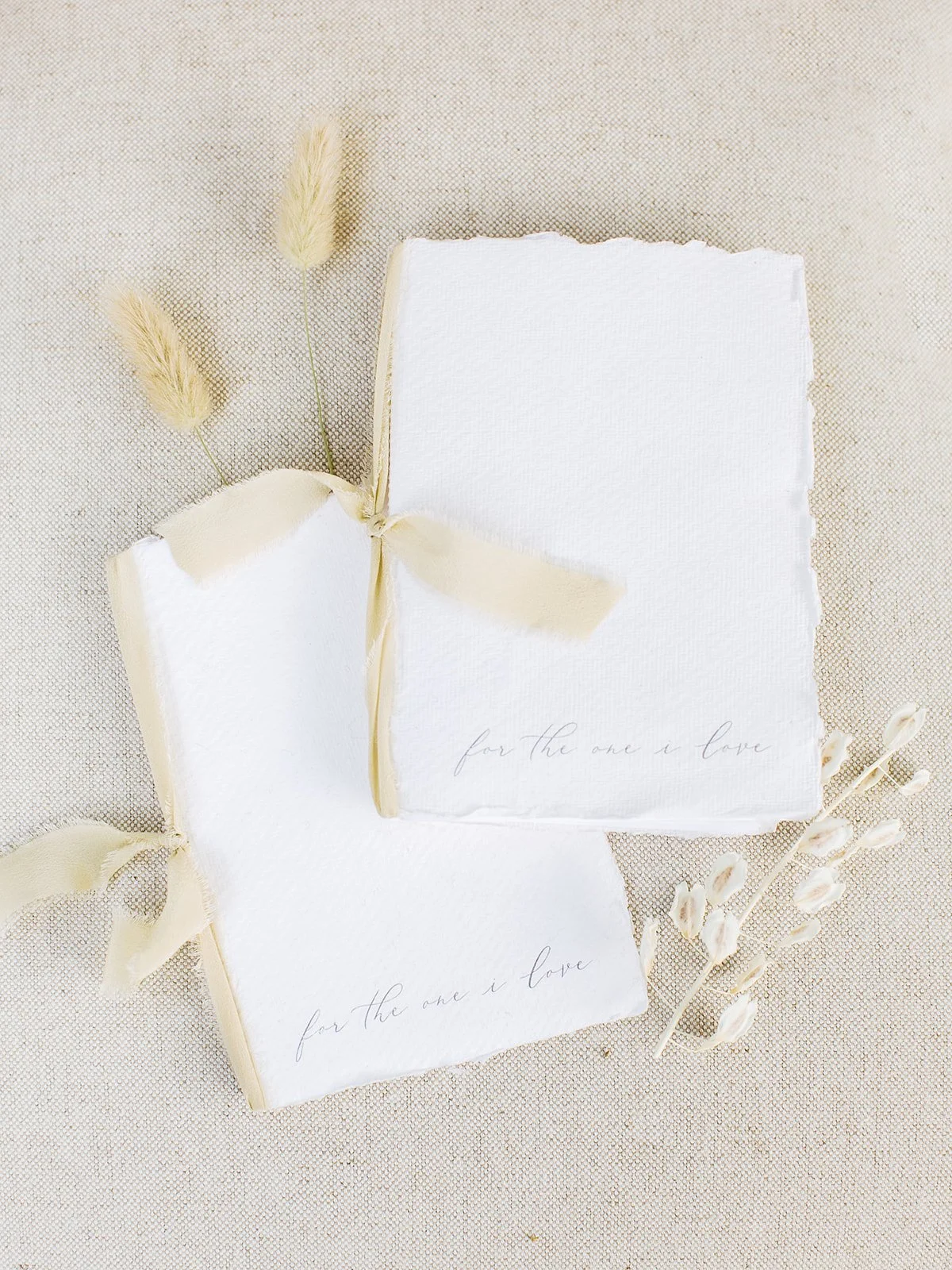 Wedding vow books crafted with handmade paper and plant-dyed silk, designed to complement a romantic outdoor wildflower wedding.