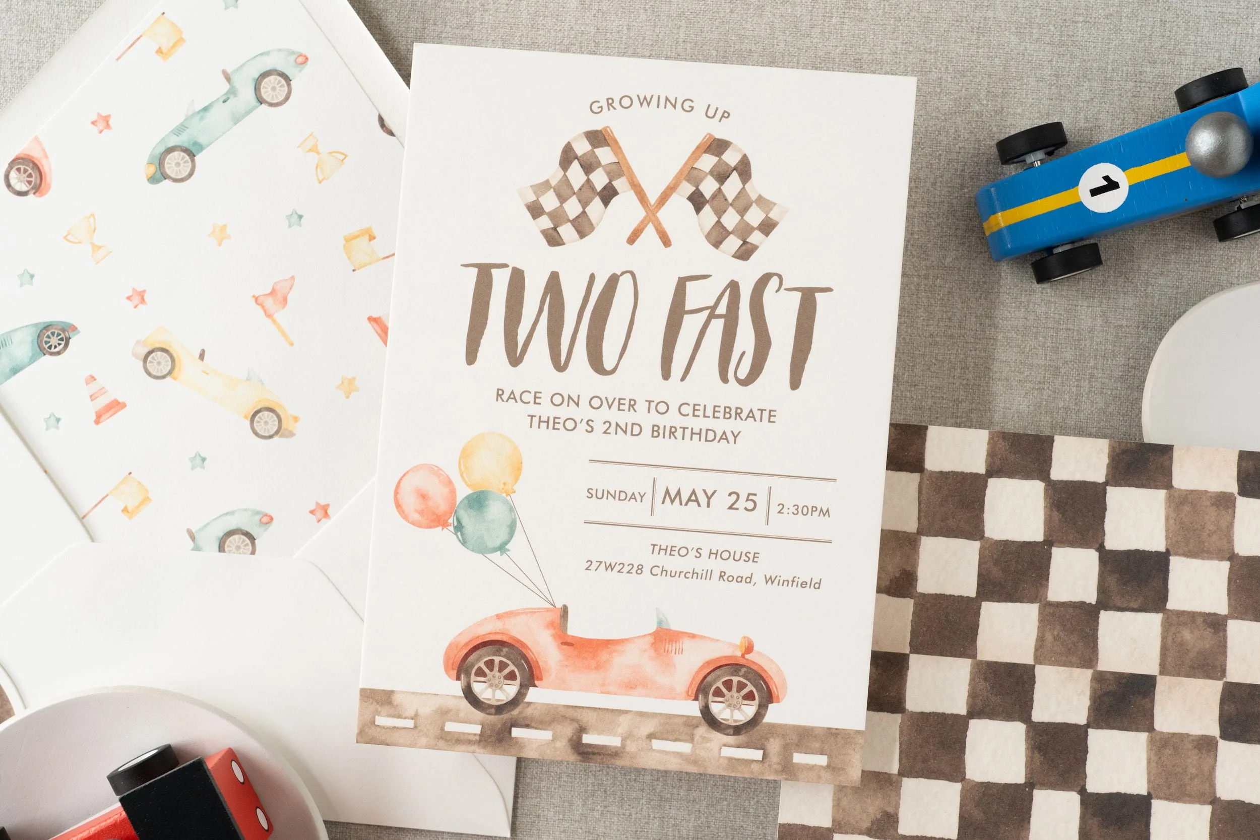 Race car-themed second birthday stationery suite with playful watercolor cars, checkered flag patterns, and motorsport-inspired paper details.