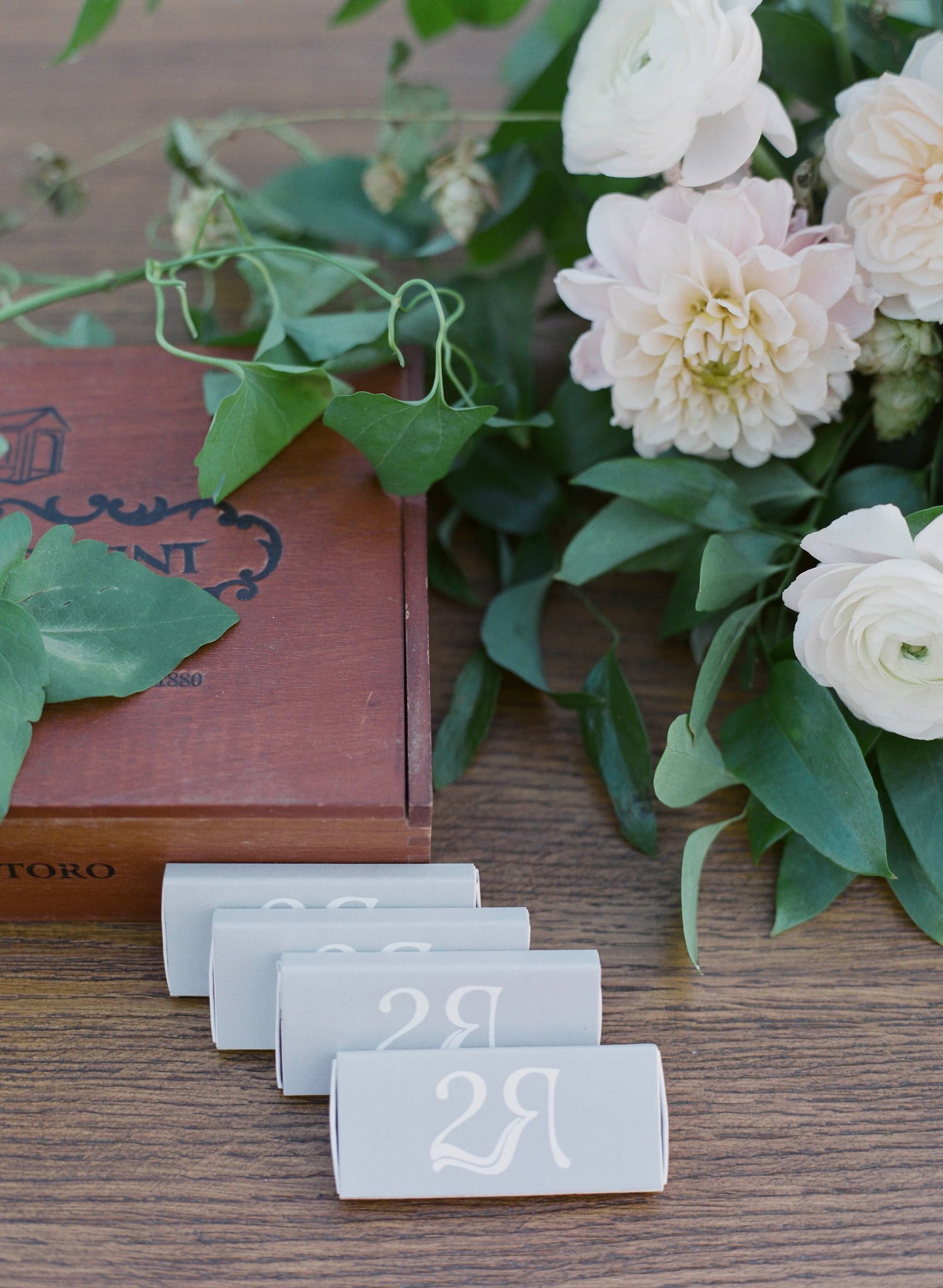 Coordinated wedding day stationery including custom cigar matches, ceremony programs, acrylic seating chart, signature cocktail signs, menus, place cards, and table numbers for an elegant fall wedding in Steamboat Springs.