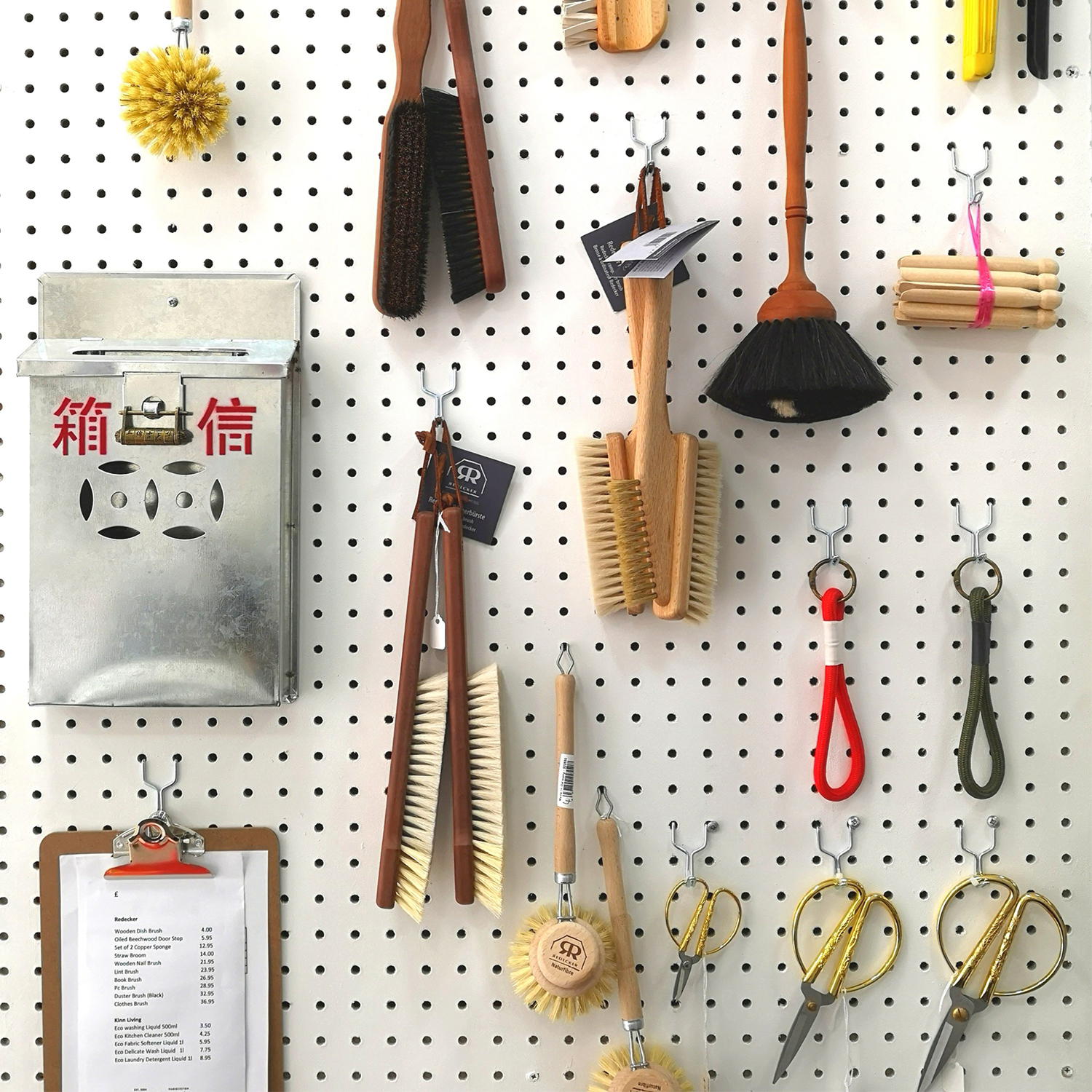 Garment-care brushes, scissors and useful objects displayed on a pegboard at The Steam Room in Haggerston