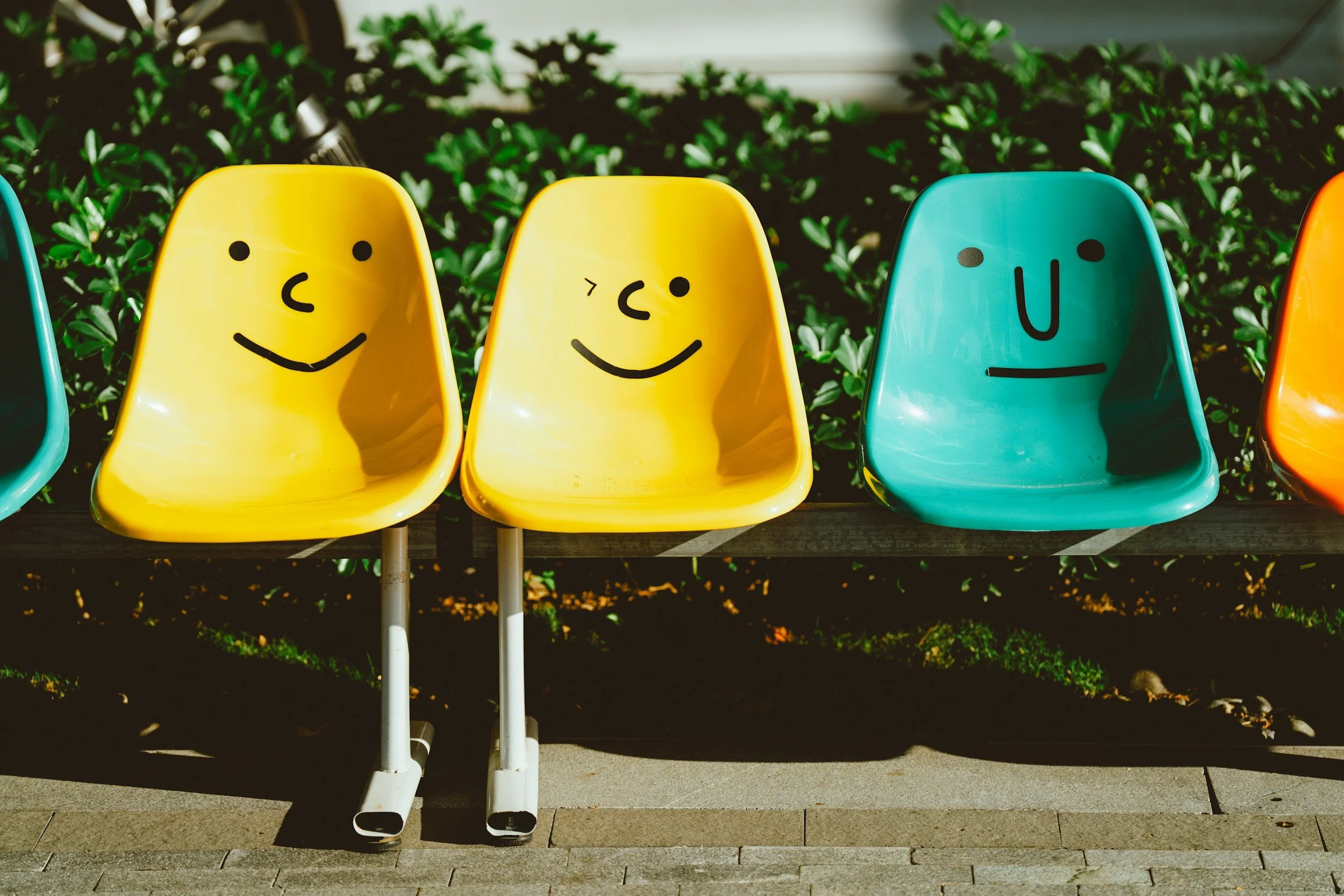 three colorful chair with faces drawn on them