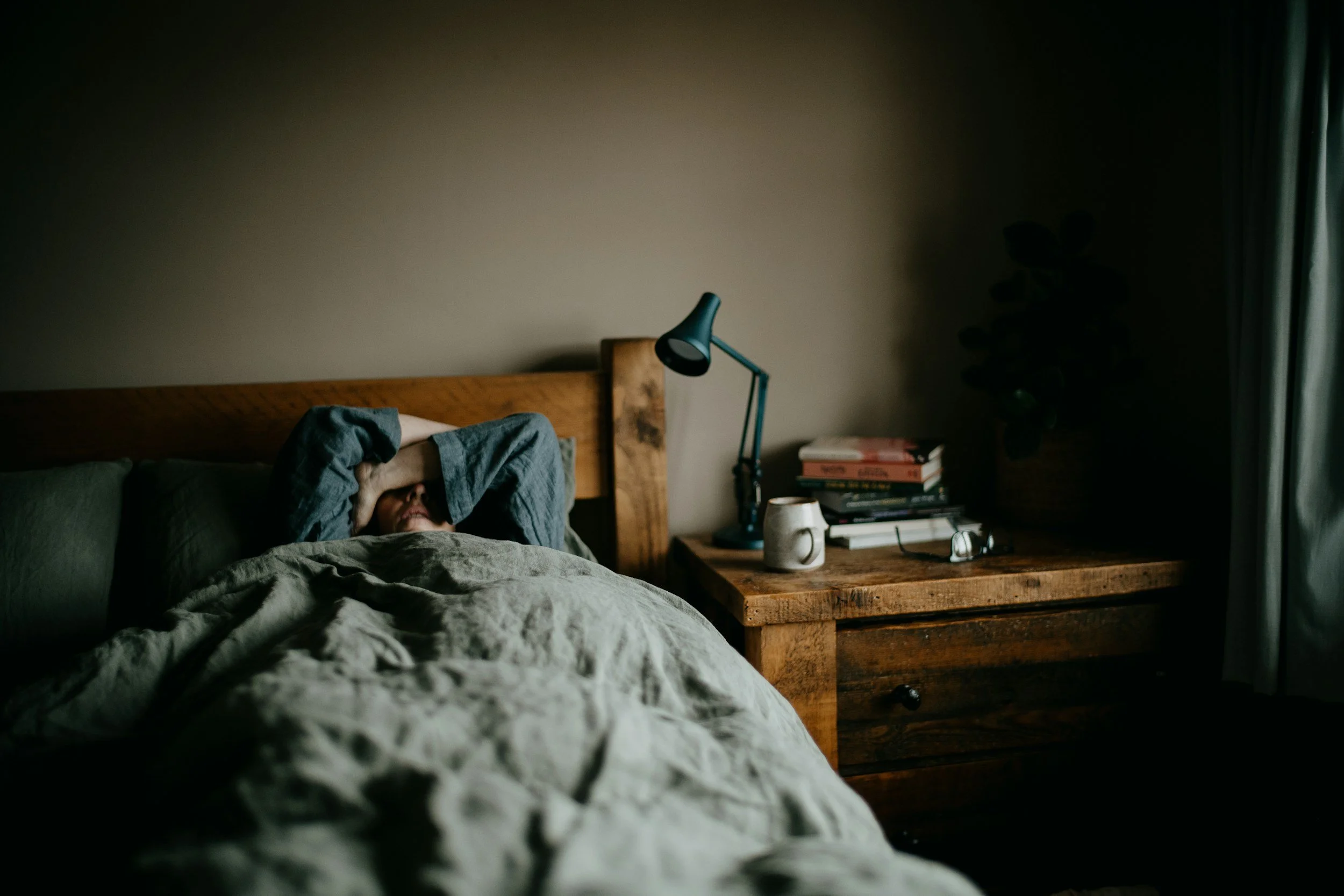 Young adult hiding their face representing grief and heaviness from parent loss