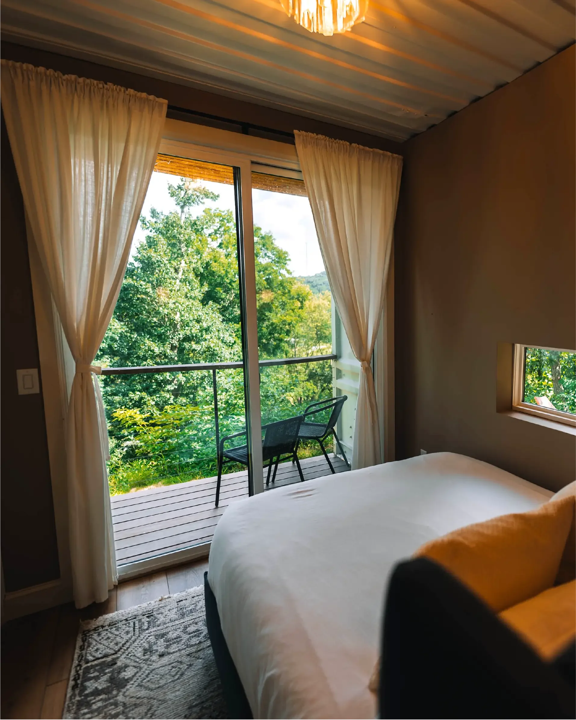 Bedroom at The Overlook cabin with a sliding glass door opening onto a private balcony with forest views