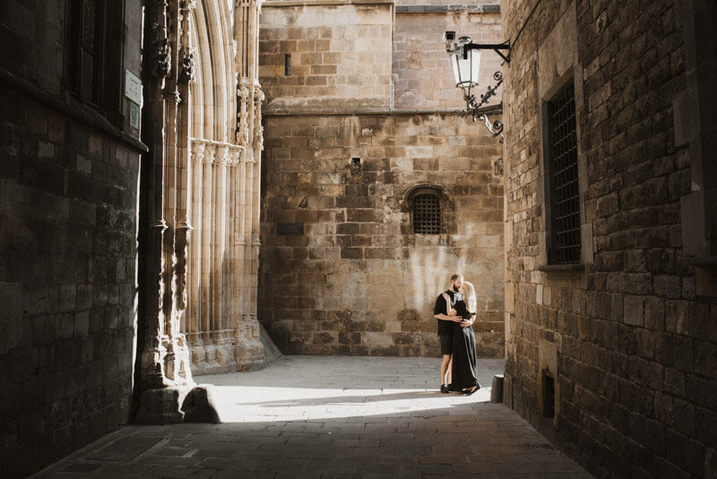 Young couple sun illuminated old Gothic architecture