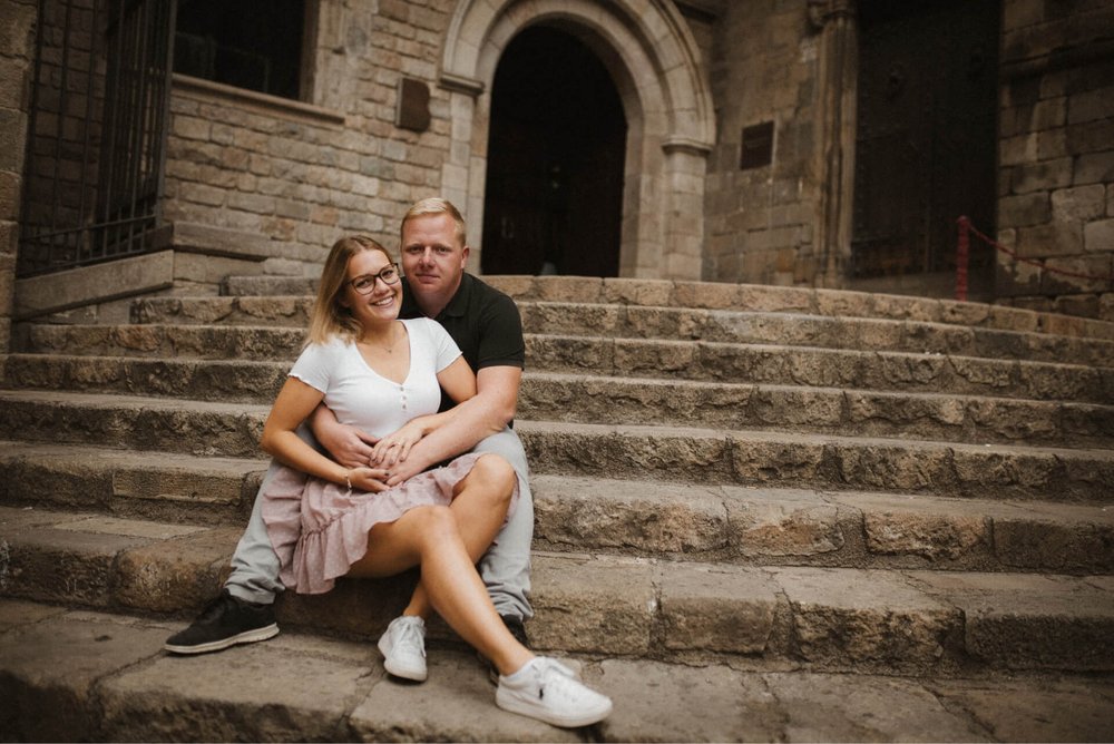 Couple sitting on bench hugging in gothic quarter