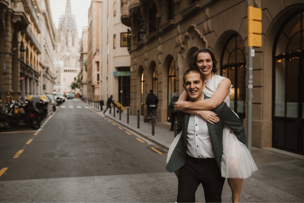 couple piggyback photoshoot idea with cathedral in the background near via laitana