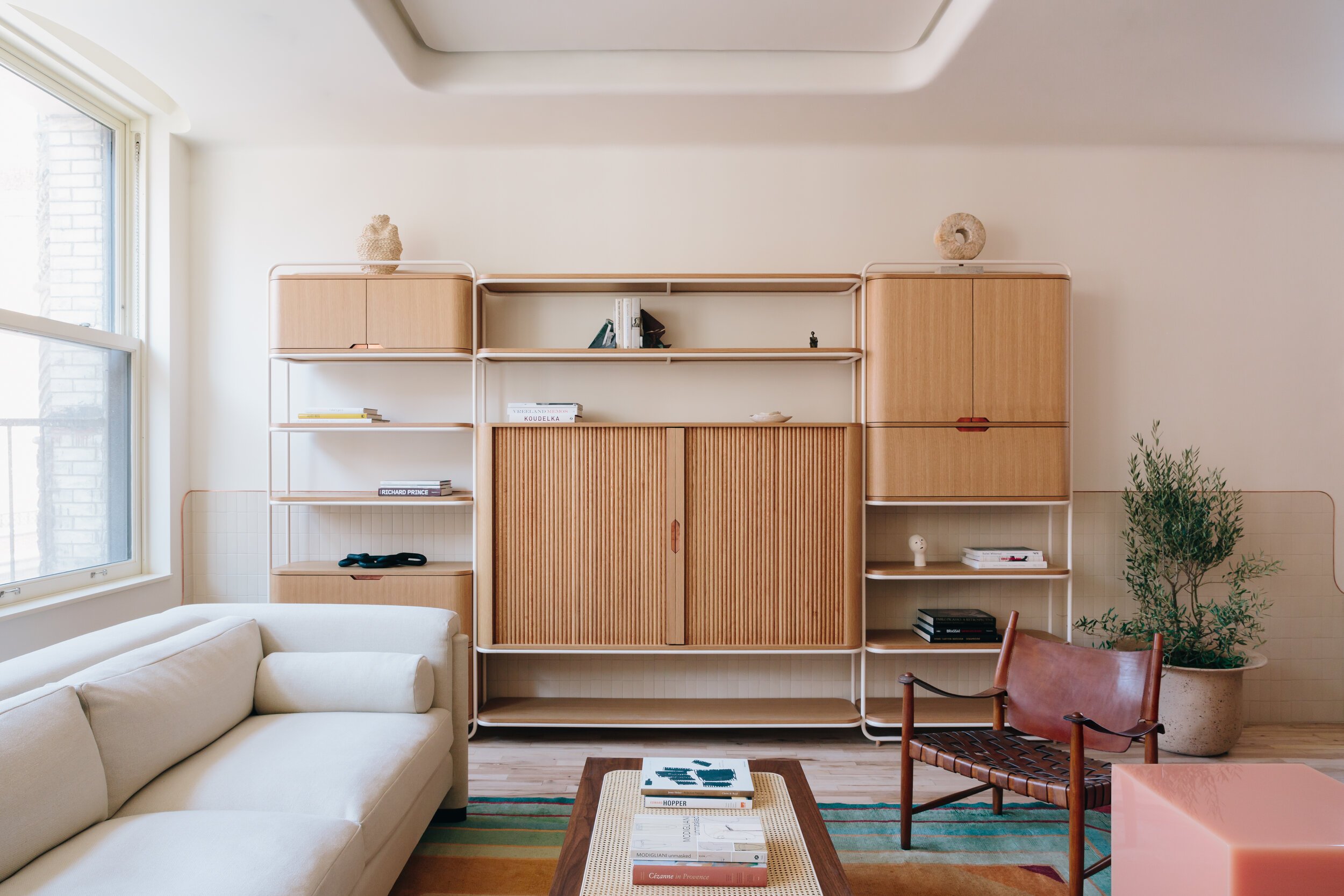 a minimal new york apartment, wooden panelled curved walls, curved walls, wooden panel, wooden panelling, new york, apartment, minimal and stylish, light and white living room, 