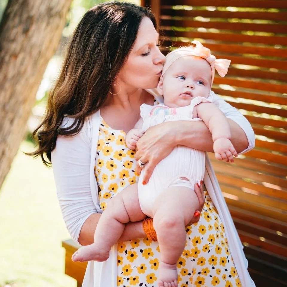 Intended parent kissing her baby daughter's cheek after a successful donor embryo transfer with Embryo Connections