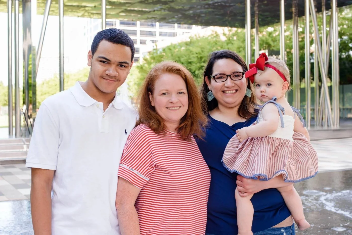 Family built through embryo donation smiling together outdoors