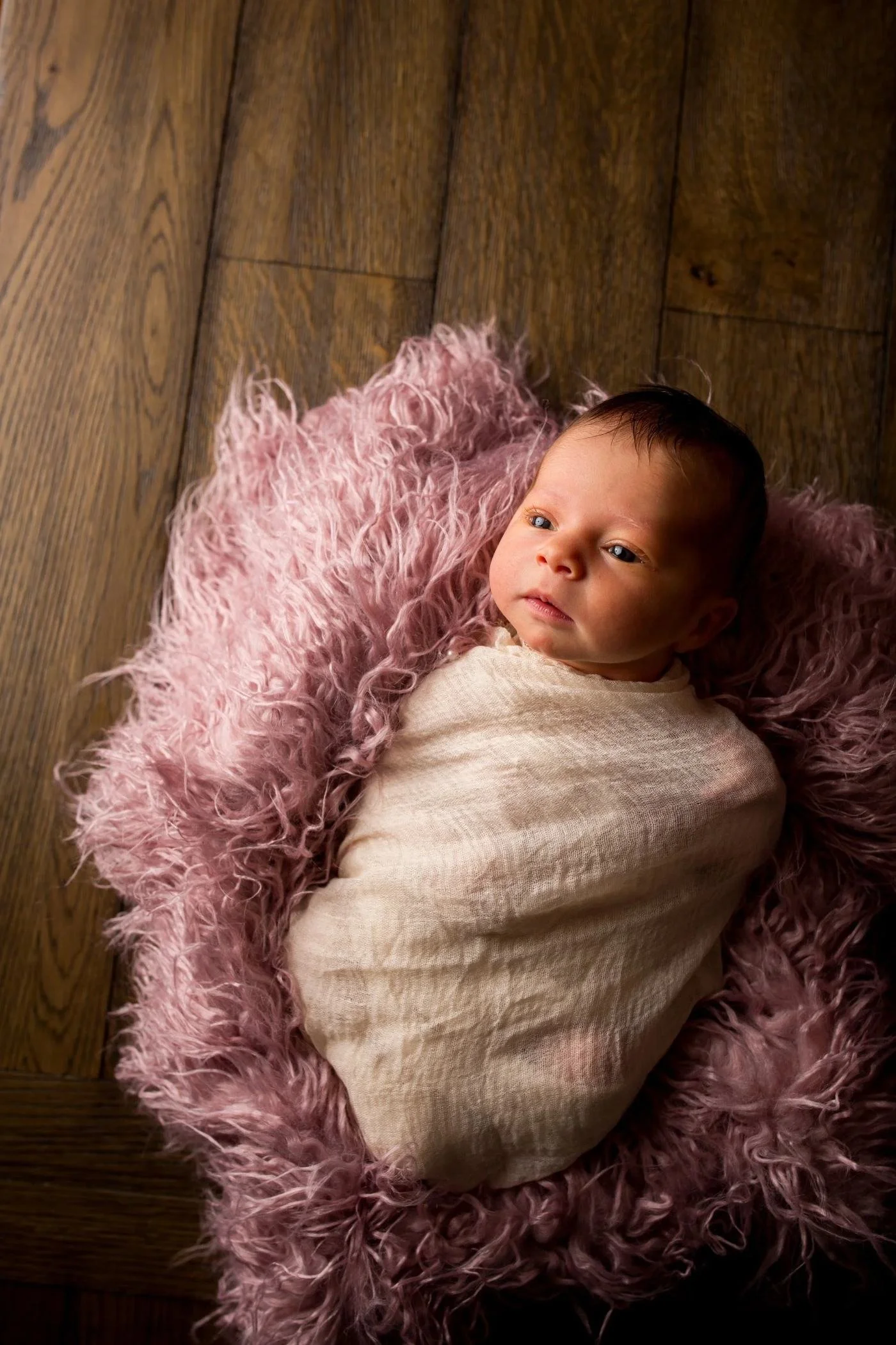Child born through embryo donation lying on a pink blanket