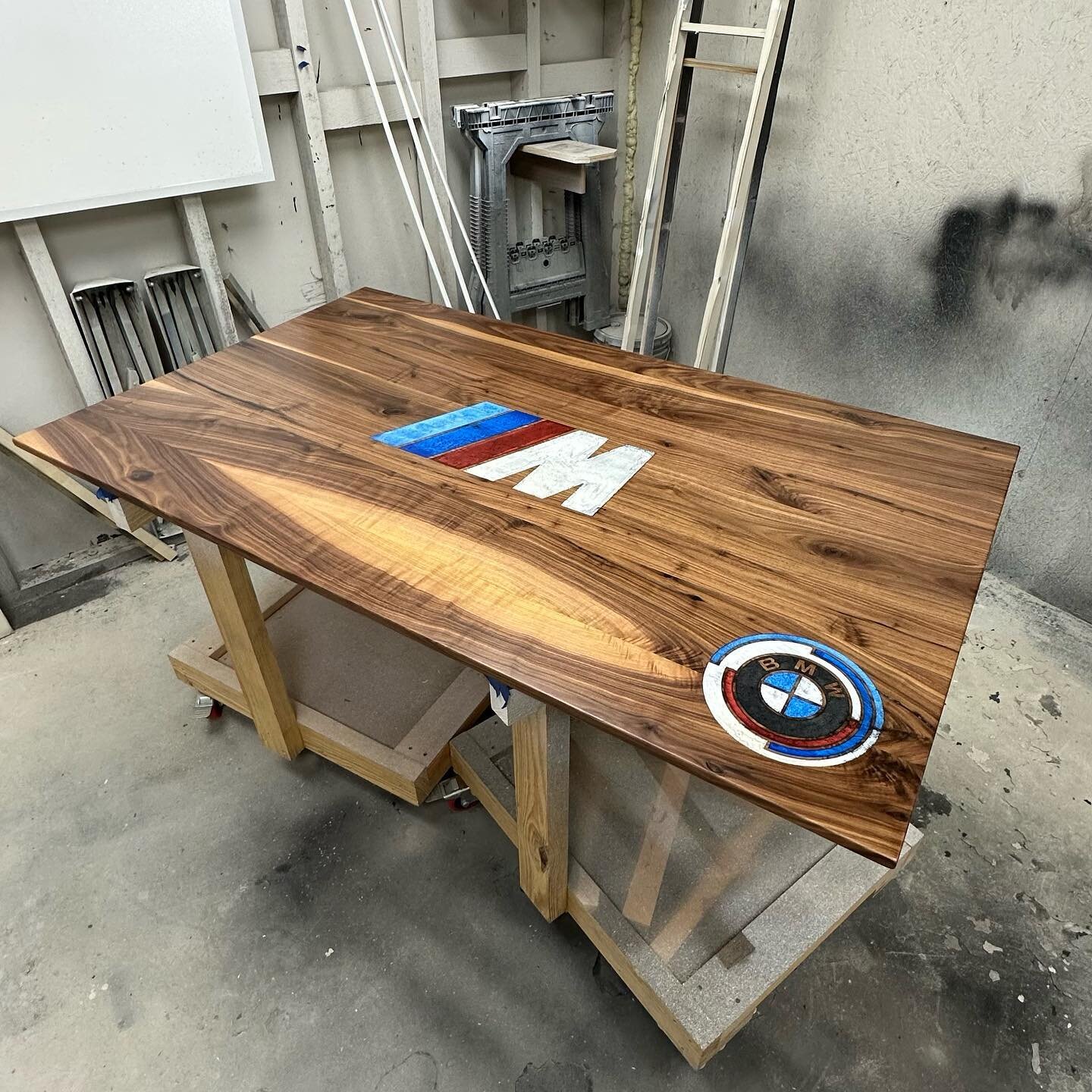 Walnut, epoxy, laser engraving, and BMWs. 

Custom tables can be as custom as you want. If it can be engraved, we can put it on a table or wall art.