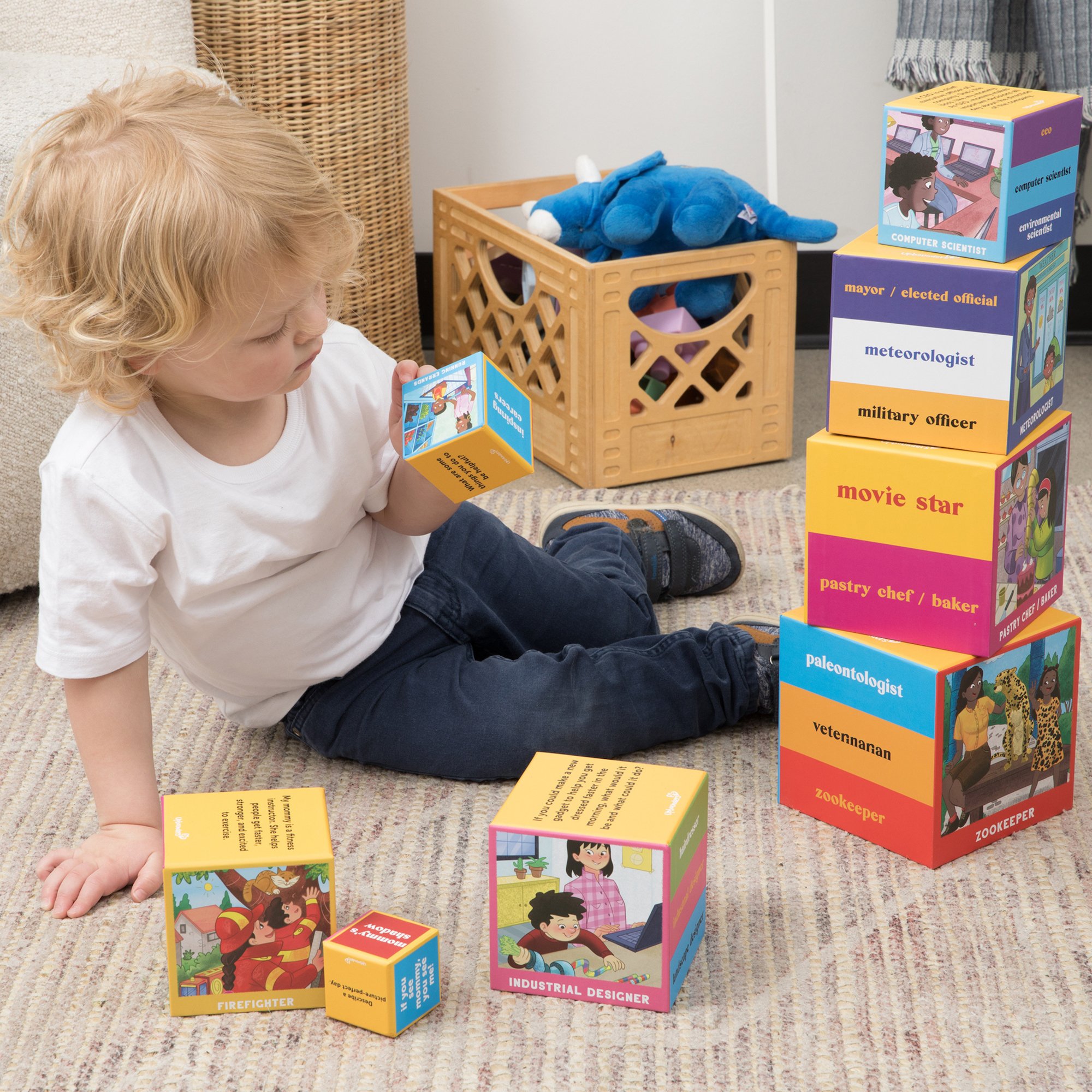 STKCUBE-MOM_LIFESTYLE IMAGE_boy in playroom inspecting artwork on Upbounders Mom Careers Stacking Nesting Toy.jpg