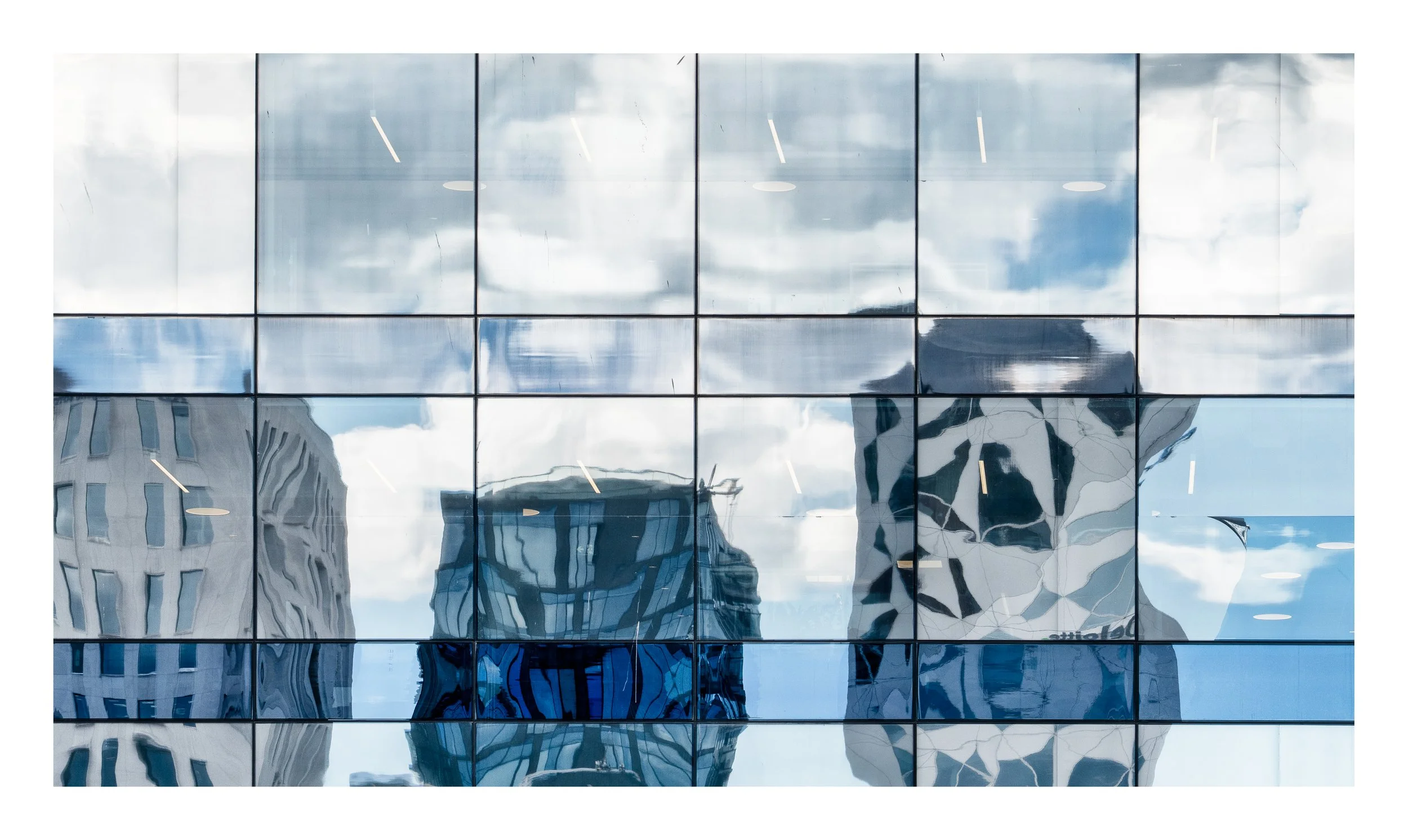 Reflective glass window panels showing distorted city buildings and clouds. Barcode Oslo. Arkitektur foto.