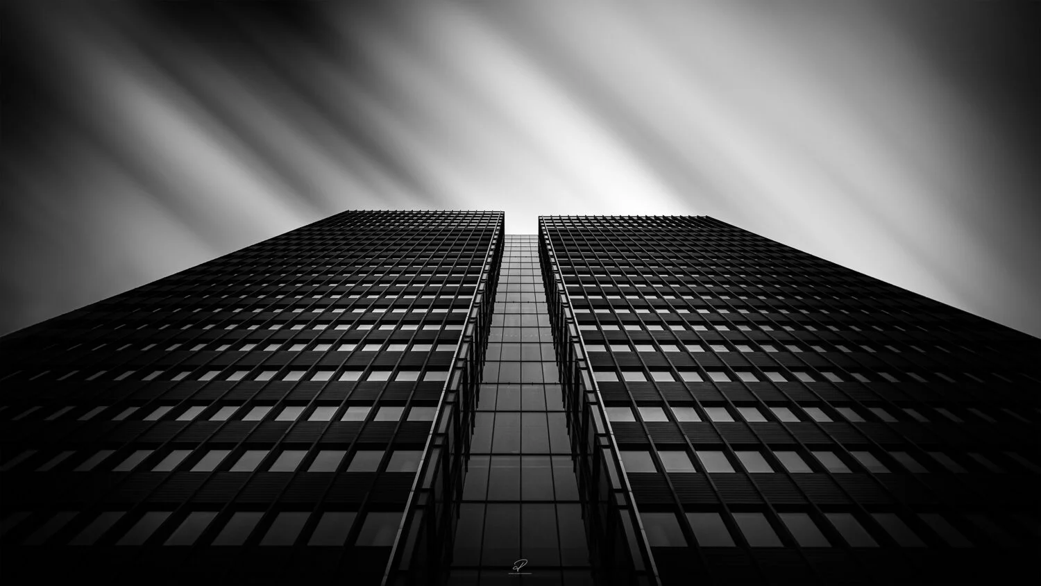 Black and white photo of a modern skyscraper taken from below looking up at the building. Arkitektur foto Oslo.
