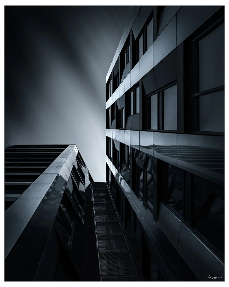 Low-angle view of modern office buildings with reflective glass windows at night. Arkitektur foto Oslo.