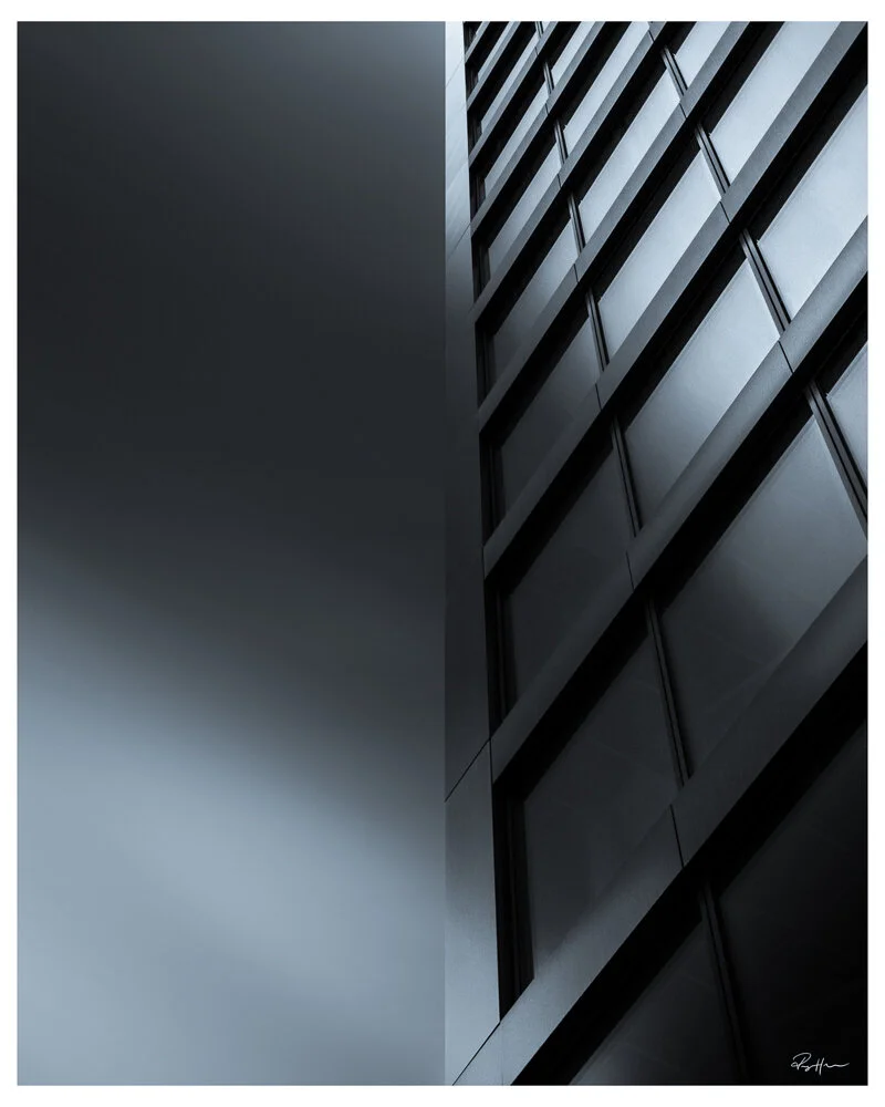 A modern glass and metal building exterior with reflective windows and sharp angles. Arkitektur foto Oslo.