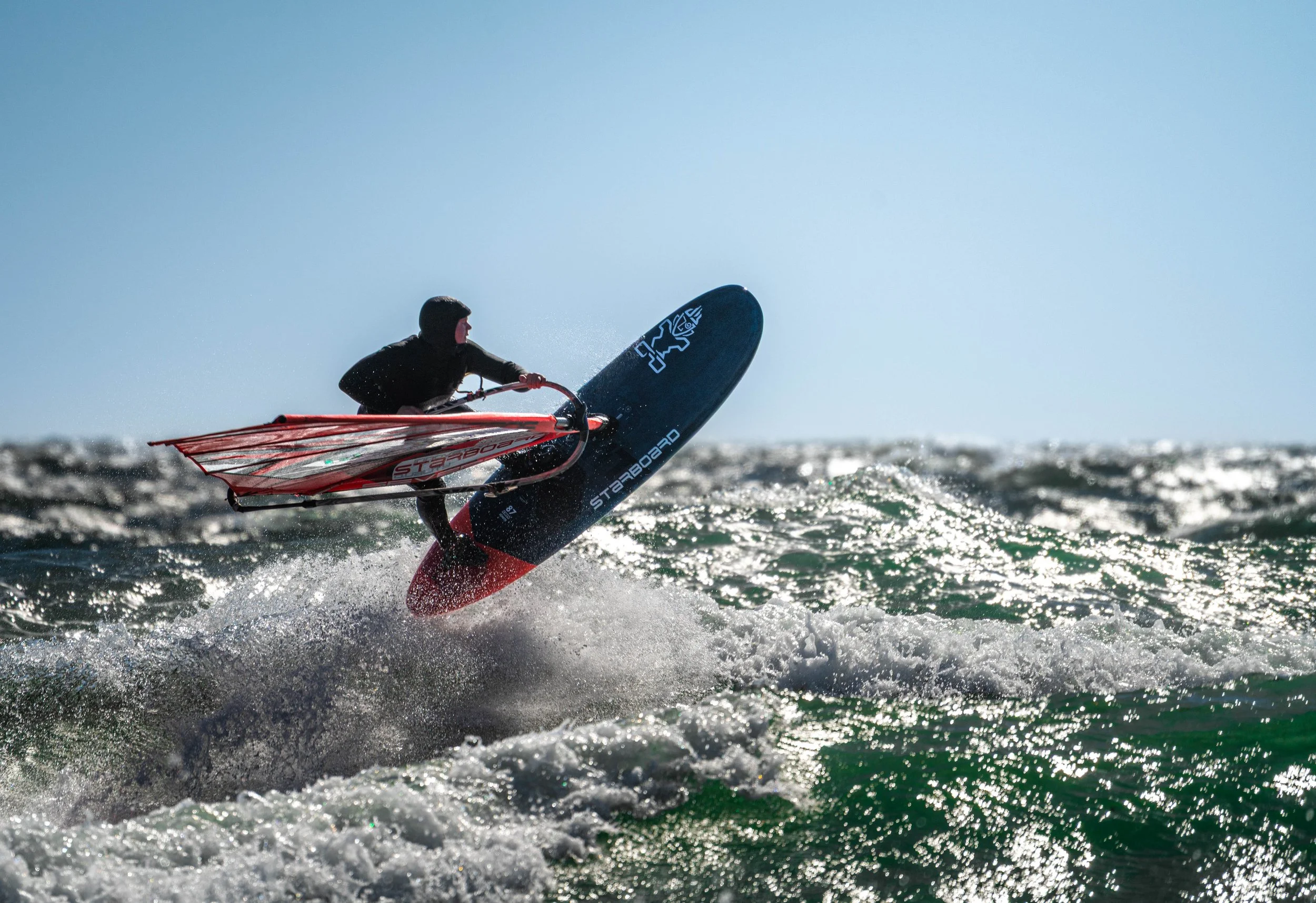 Dynamic windsurfing captured in strong coastal waves at Saltstein beach. A powerful moment of balance, motion, and energy in Scandinavian surf conditions.