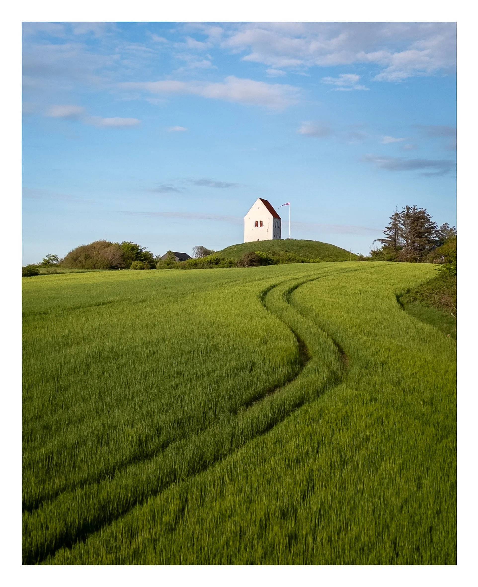 If you watched yesterday&rsquo;s Reel, this is the photograph it led to.
While exploring the Danish countryside, this small church caught my attention from above. The soft evening light, the winding tracks through the field, and the simplicity of the