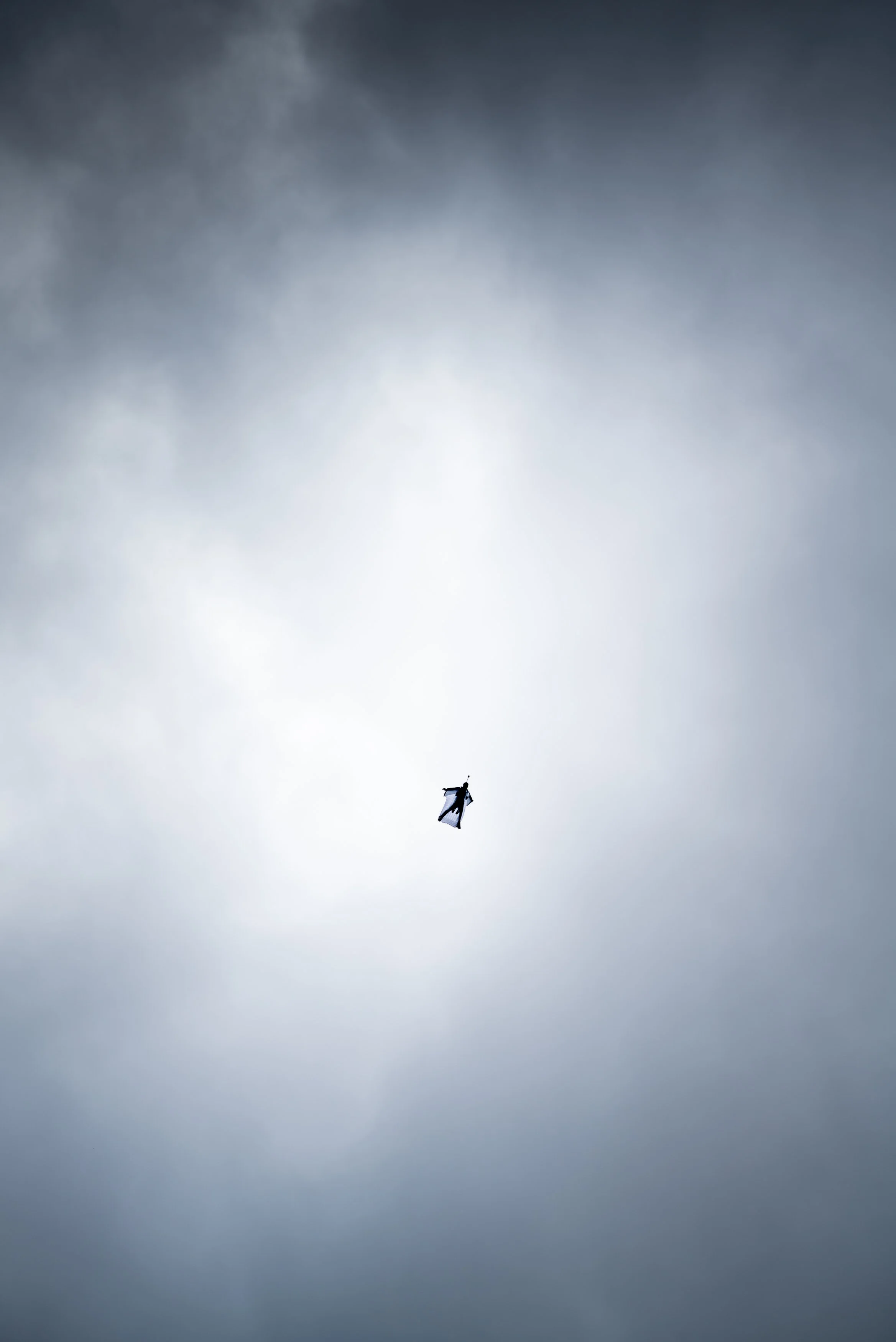 Wingsuit flight in a cloudy sky.