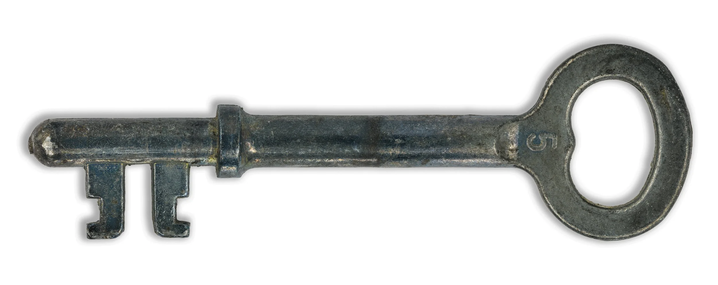 An old, tarnished metal skeleton key with a round bow, a short shaft, and a bit with two teeth. Hyperfocus detail. Focus stacking. Macrophotography. Makro foto av en nøkkel med hyperfokus av detaljer.