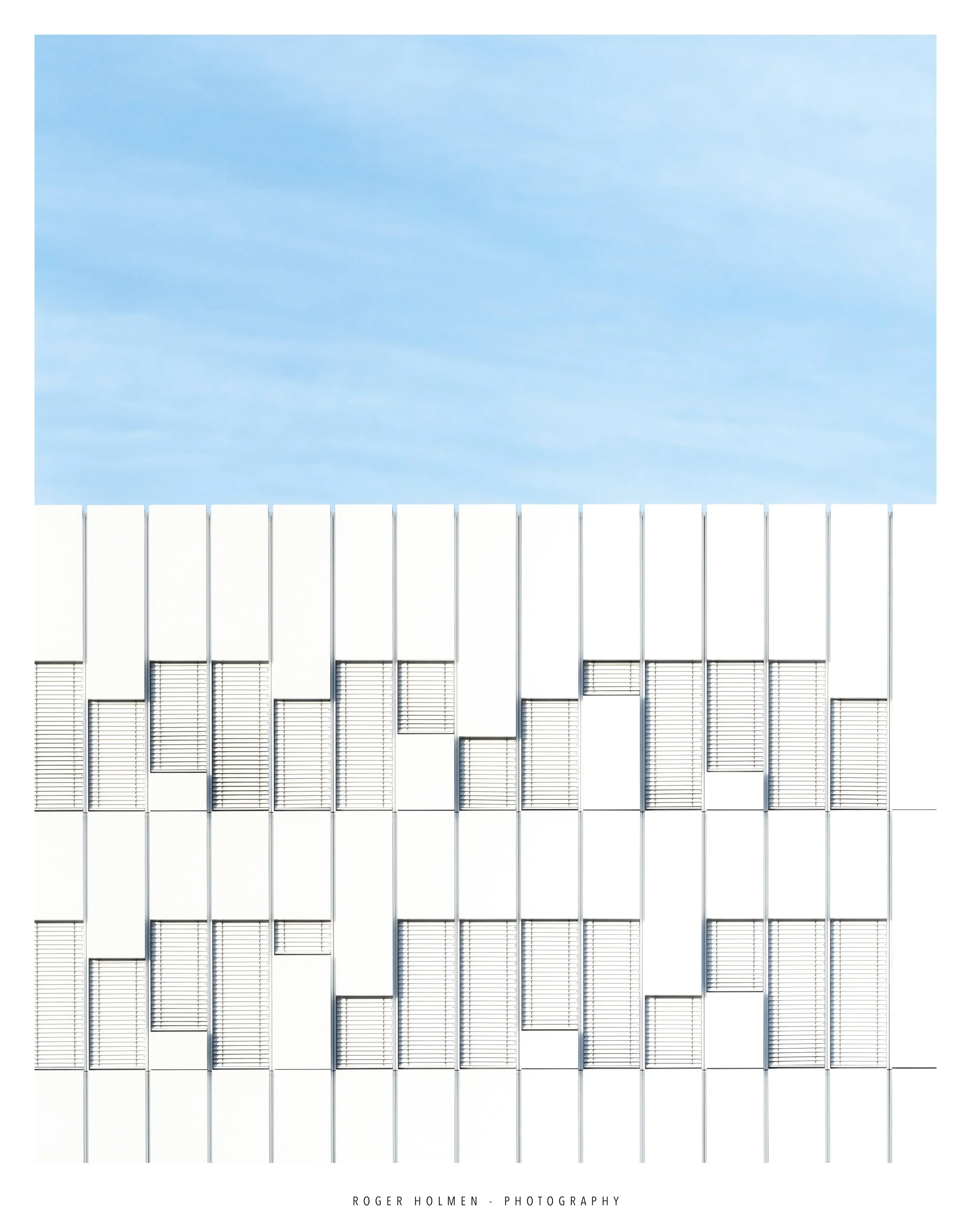 Modern building with patterned windows against a blue sky.