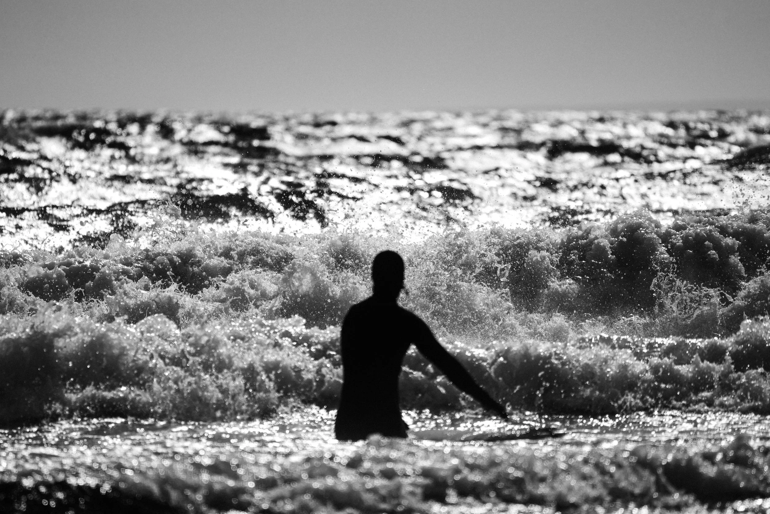 surfer photographed in silhouette waiting to enter the waves at Saltstein. Fineart photography