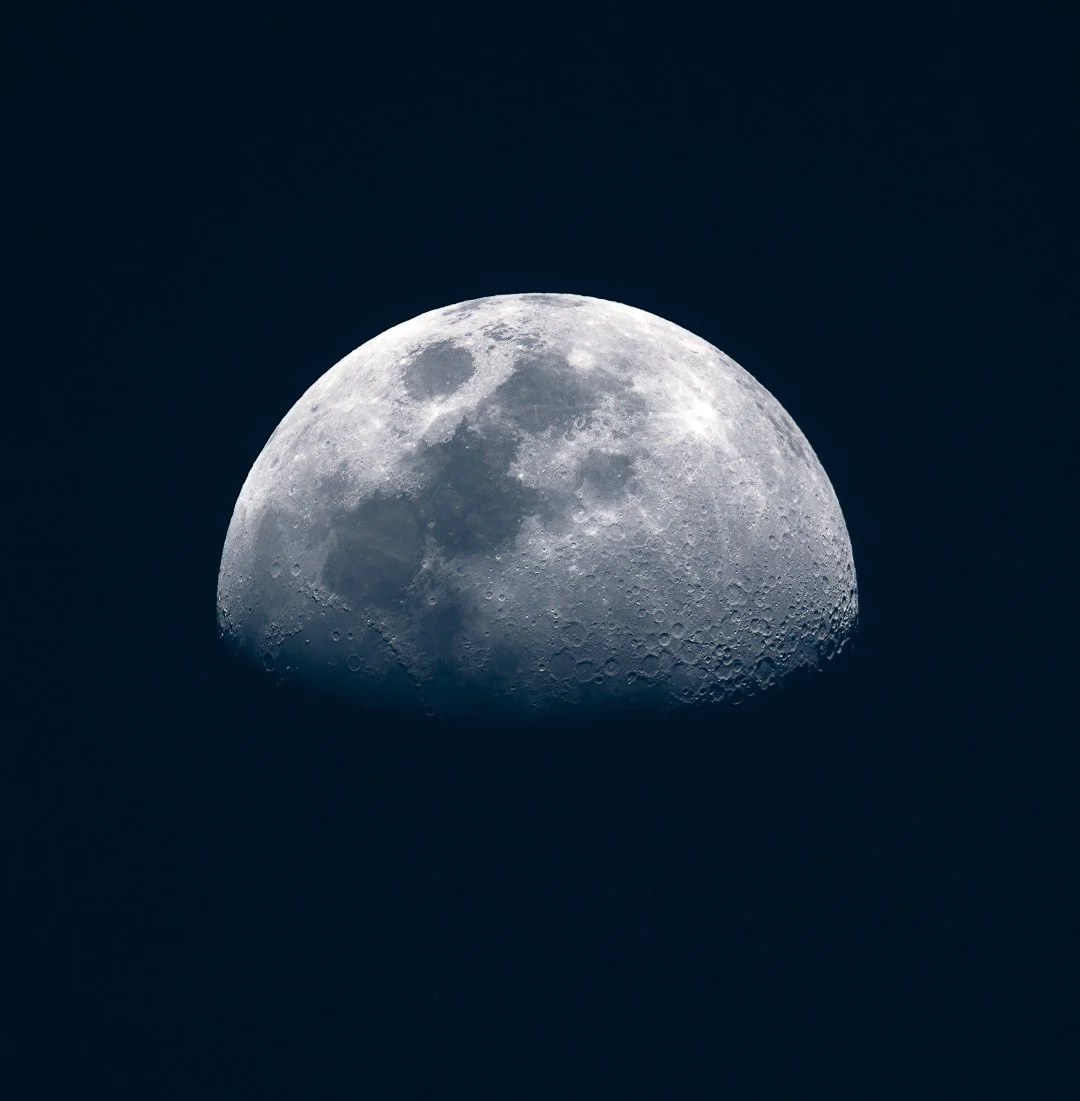 Close-up of the moon against a dark night sky, showing detailed craters and surface features.