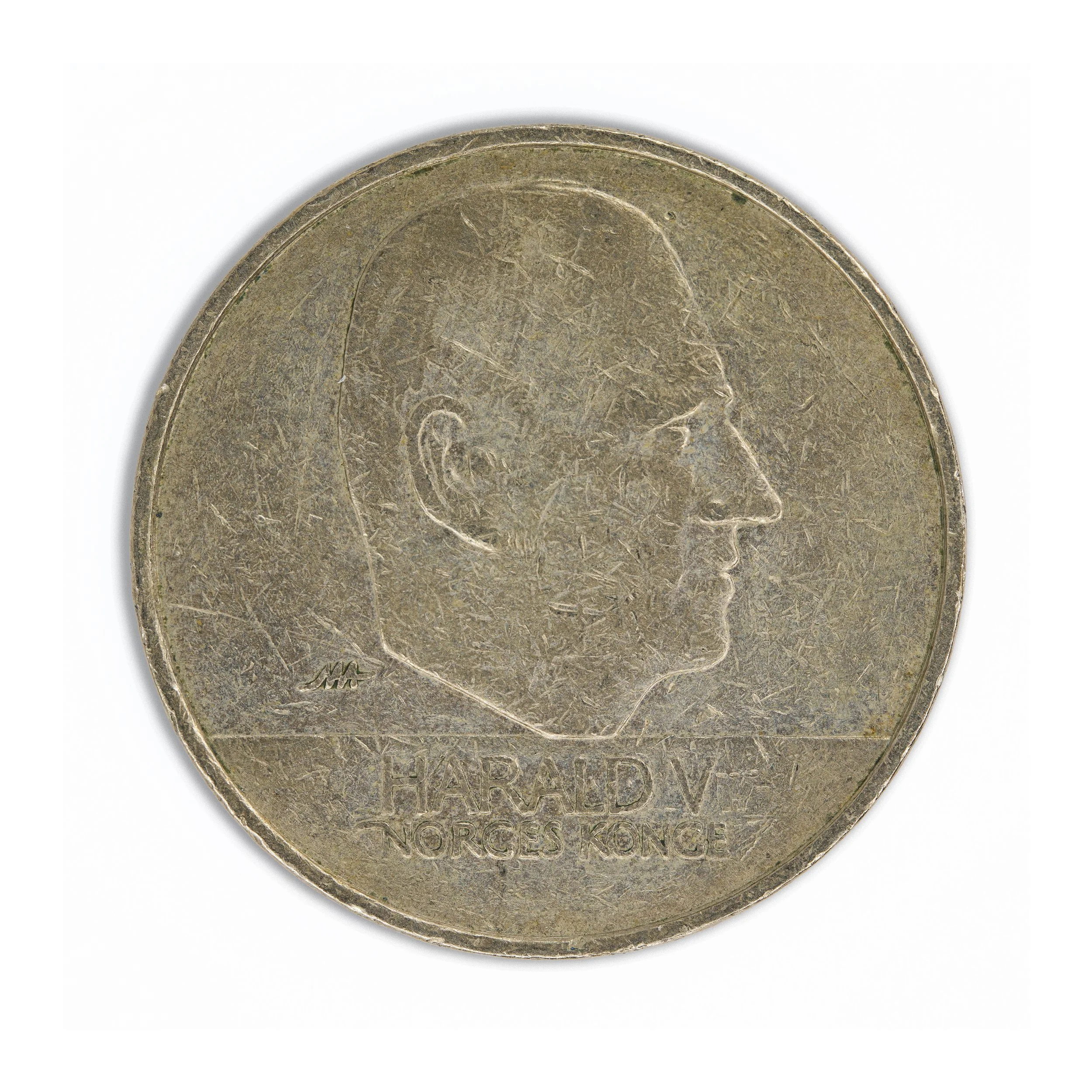 Kong Harald-20 kroner-Close-up of the reverse side of a worn coin featuring the profile of a person's head and inscriptions, including the words 'NORGE' and 'KONGE'.