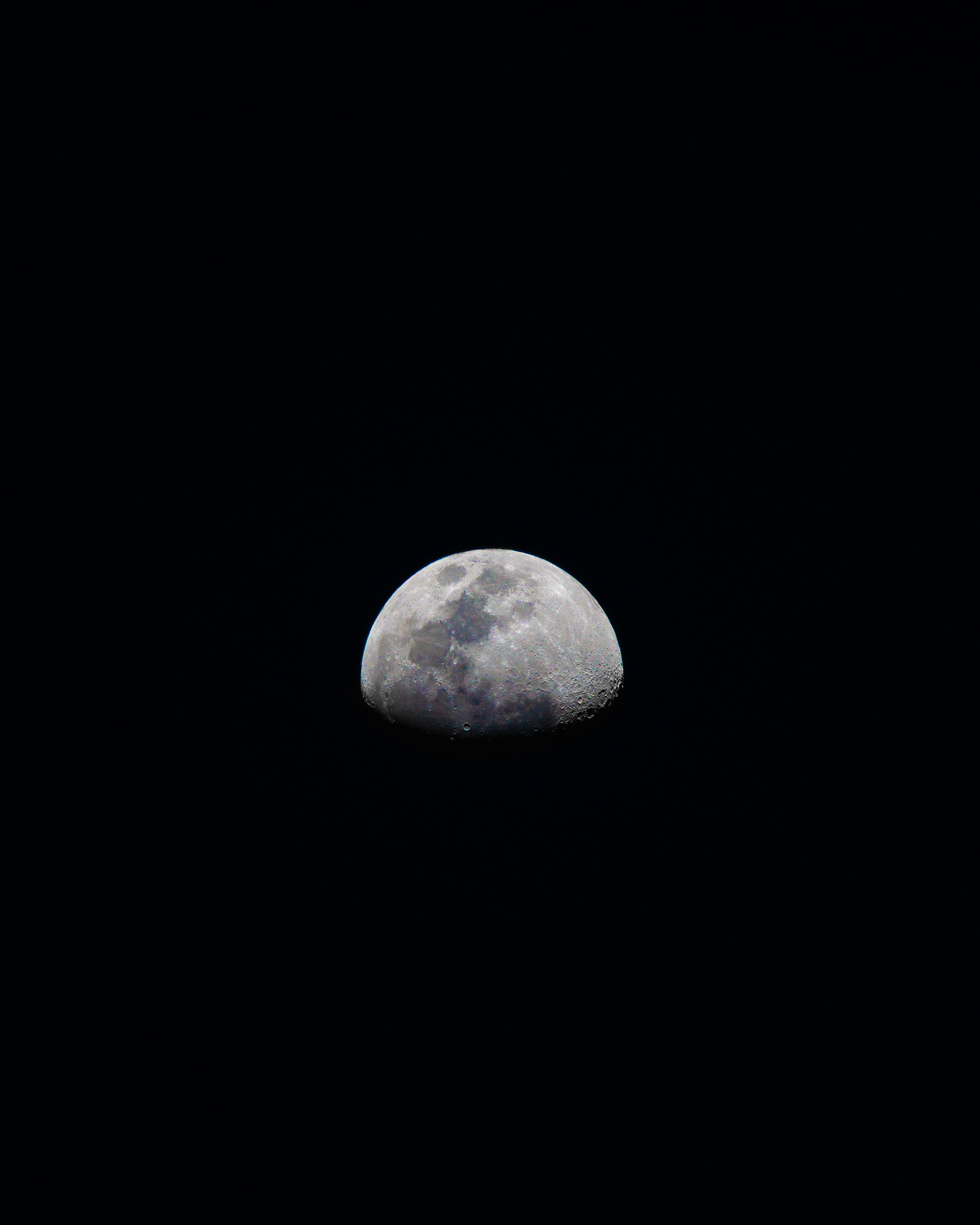 Photograph of the moon in the night sky with a dark background.