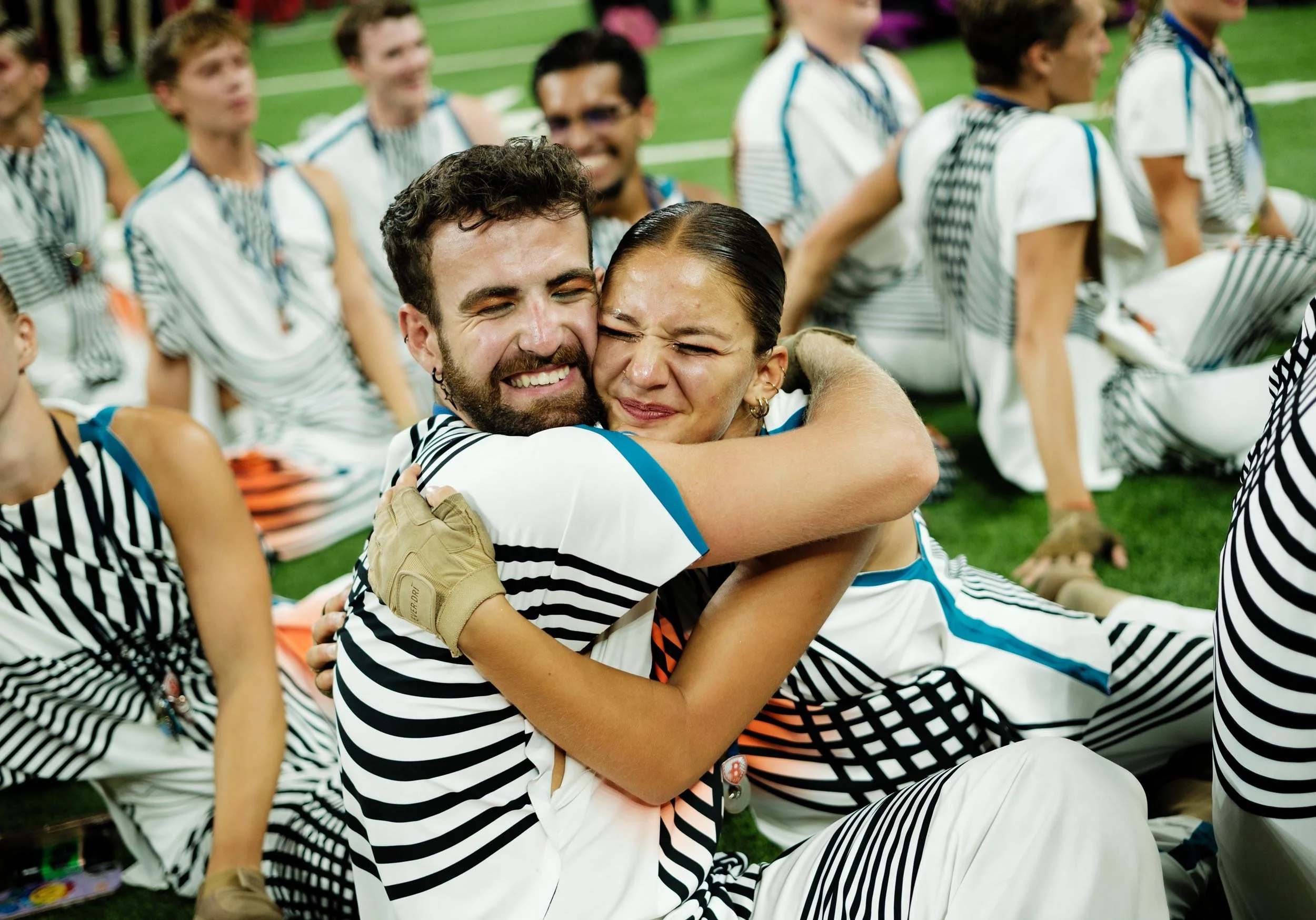 Photo of two drum corps performers hugging.