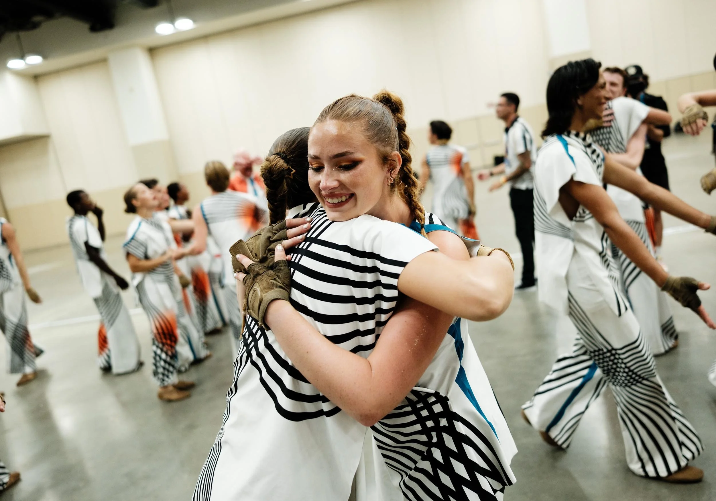 Two color guard performers hugging.