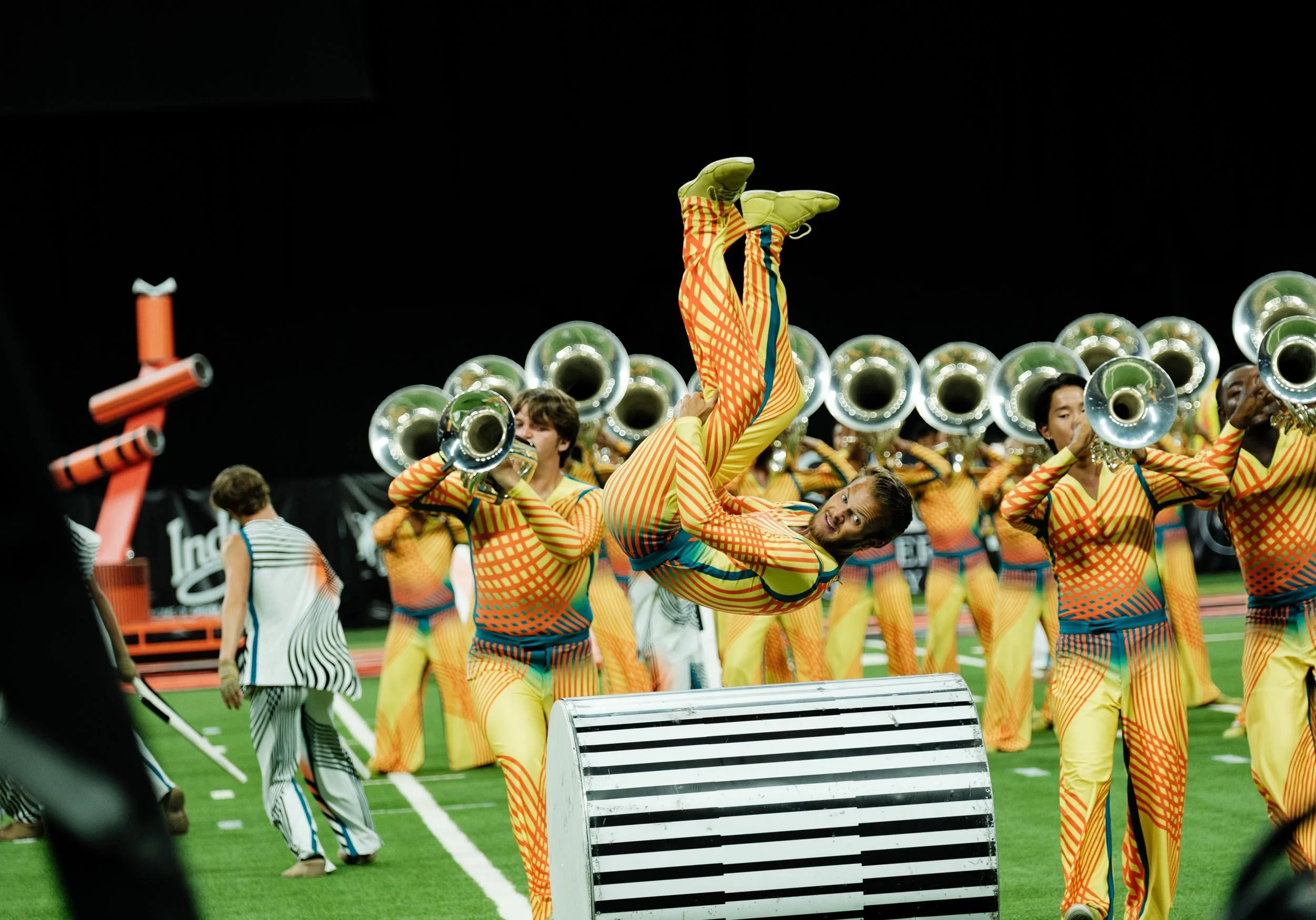 Photo of drum corps performer flipping over a set piece.