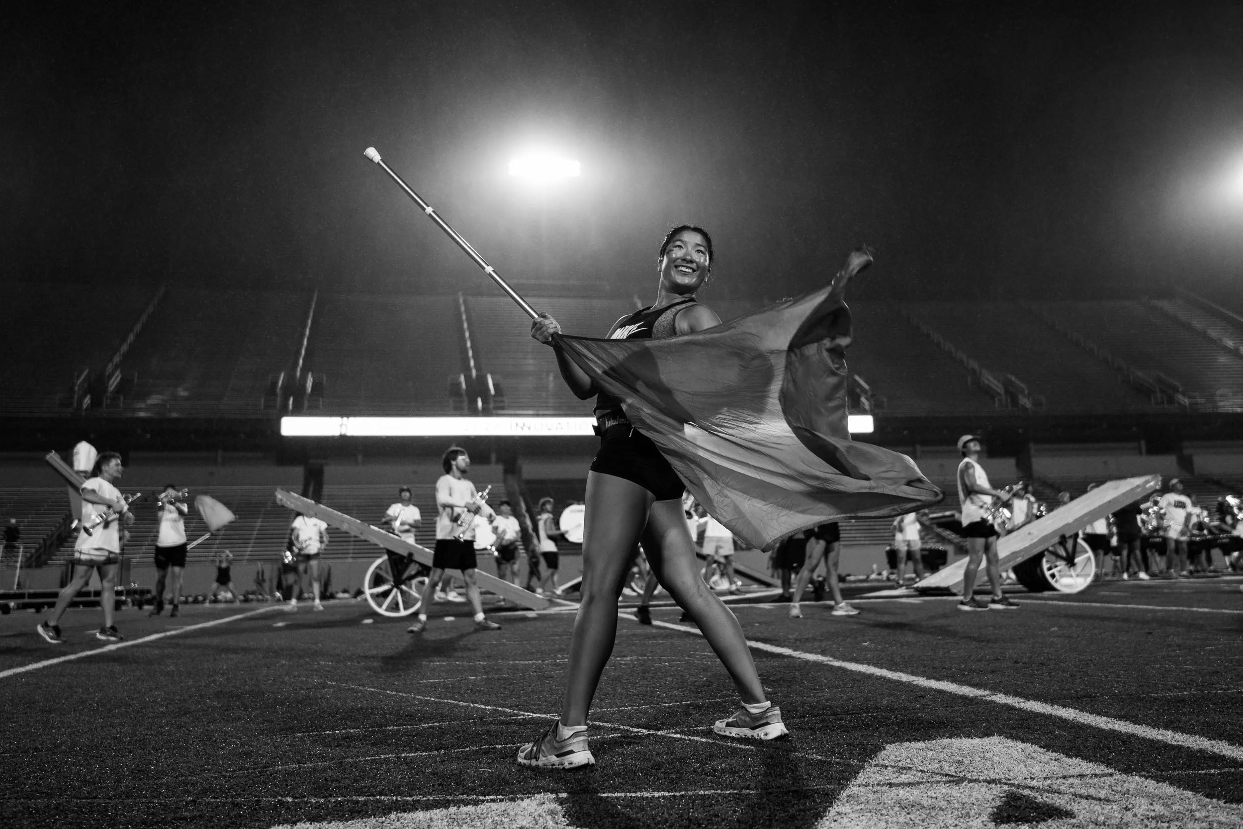 Color guard performer smiling and spinning flag.