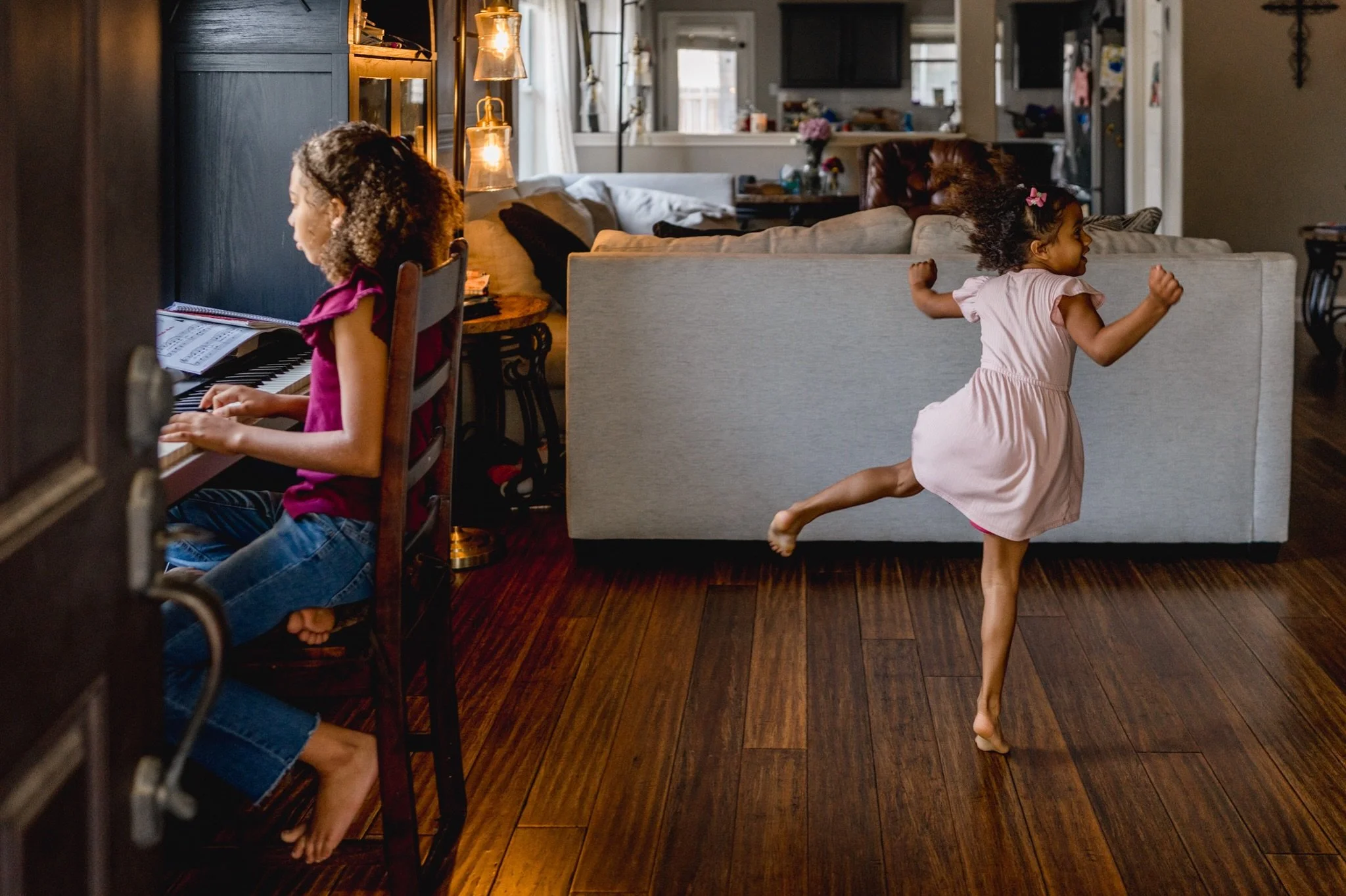 One of my favorite things about photographing families at home is getting to see what everyday life actually looks like for them.

Sisters playing the piano and dancing in the living room. Climbing into the art cabinet. A little boy climbing a tree i