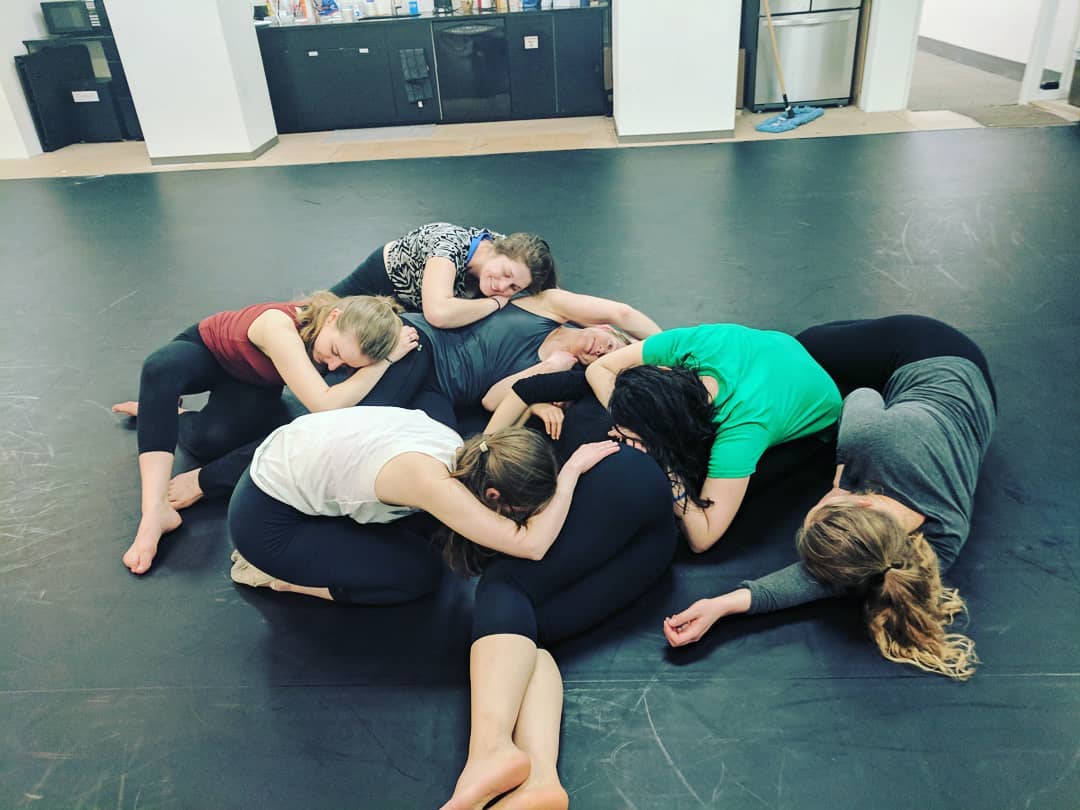  Dancers laying on top of each other about to end a dance. 