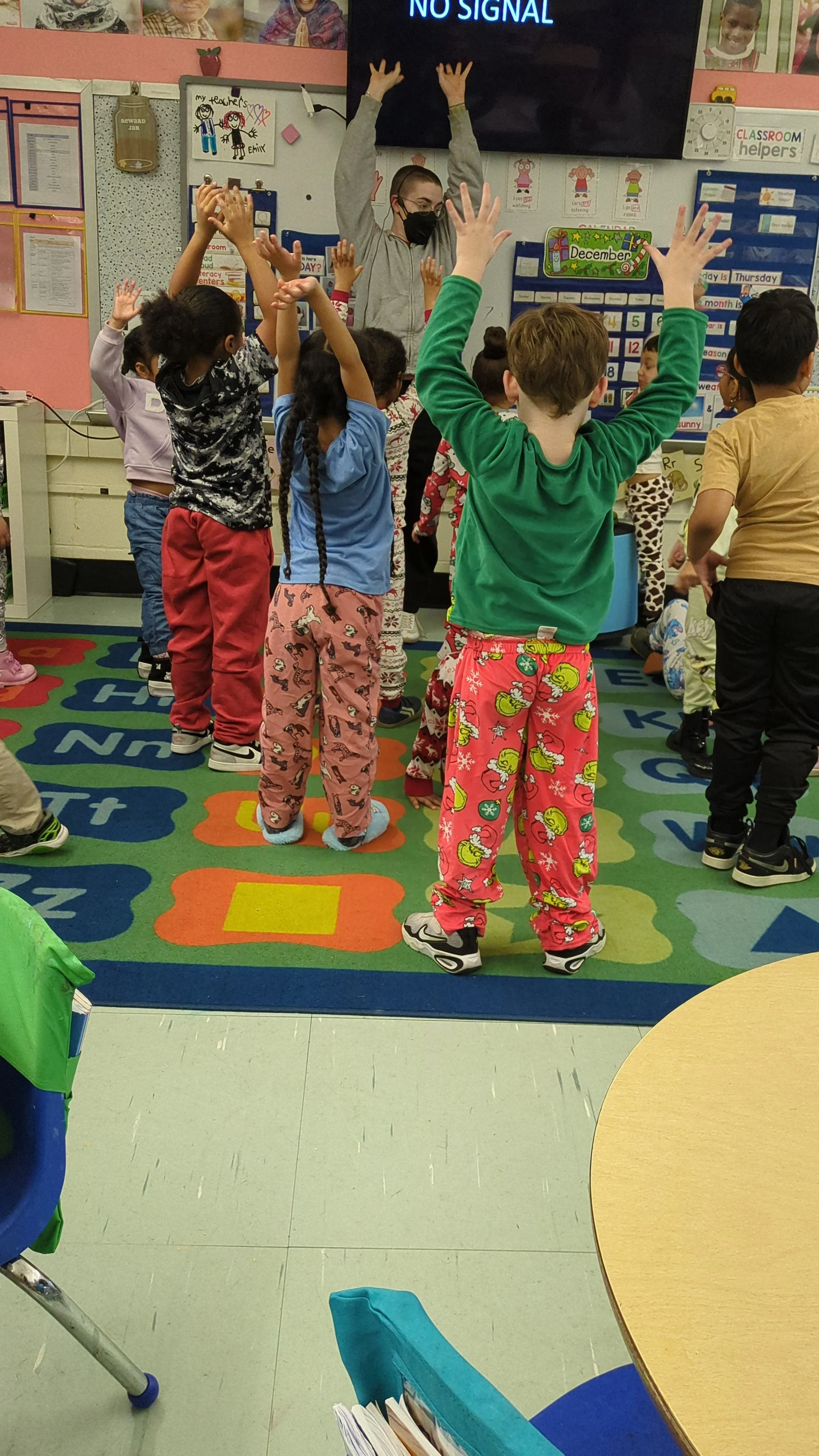  Teacher Dawn in classroom with arms raised and students seeing them with arms raised on a classroom mat 