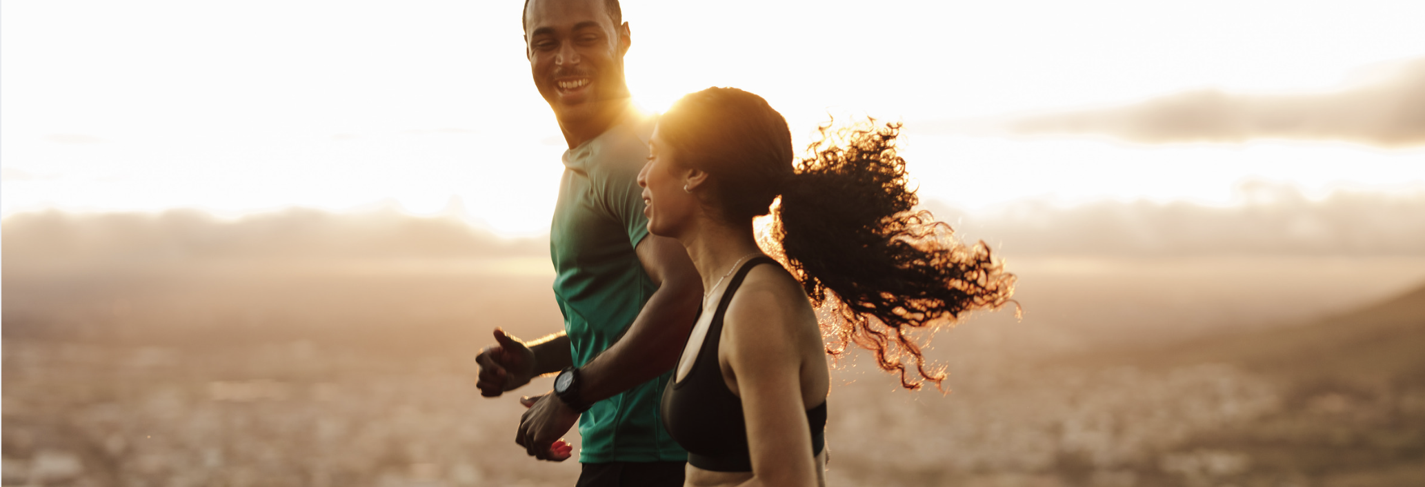 A couple runs together at sunrise, reflecting energy, resilience, balance, and the long-term wellness needed to sustain peak performance.