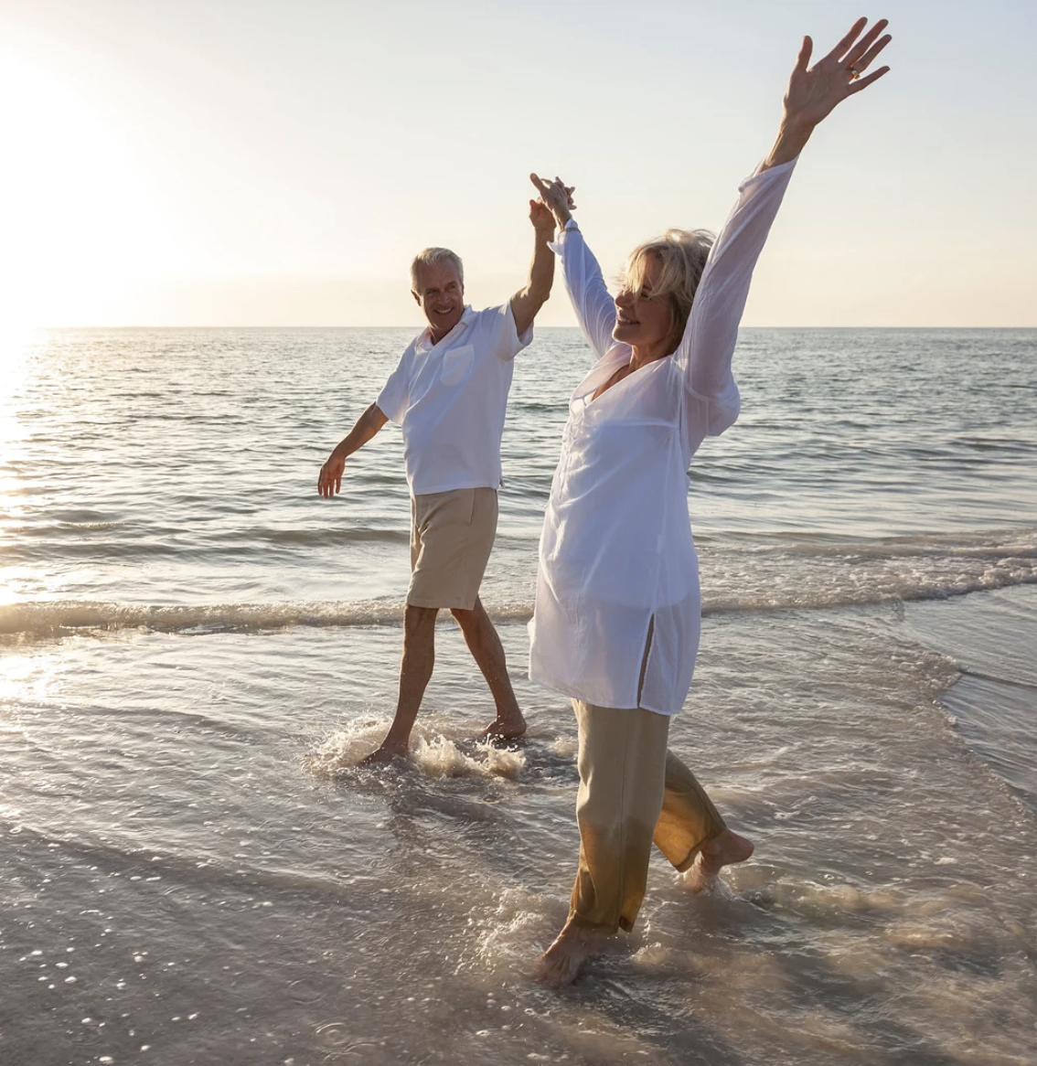 Happy couple walking in the water, loving life
