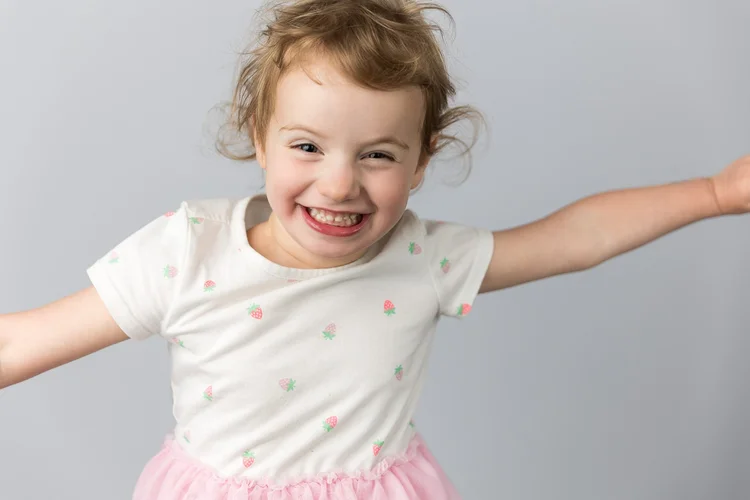 Child stretching their arms out with a joyful expression
