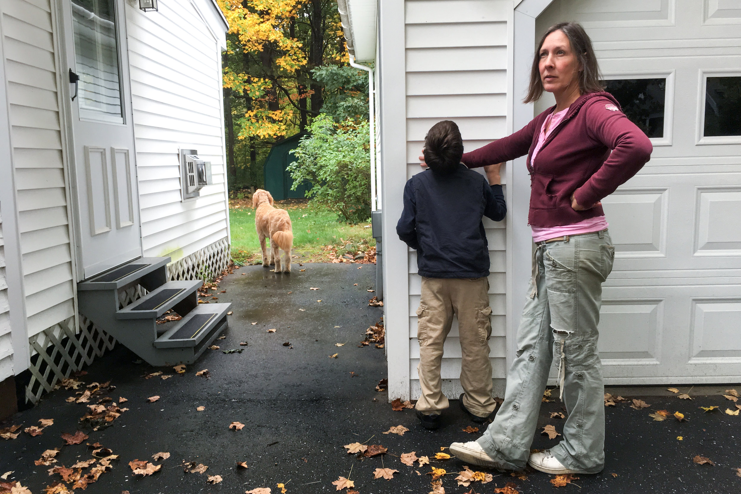  "He has his favorite spots." Christy Shake blocks her son from biting at the siding on a neighbor's house while their dog, Nelly, looks for squirrels in the yard on October 8, 2017 in Brunswick, Maine. &nbsp;Calvin is very tactile and likes the feel