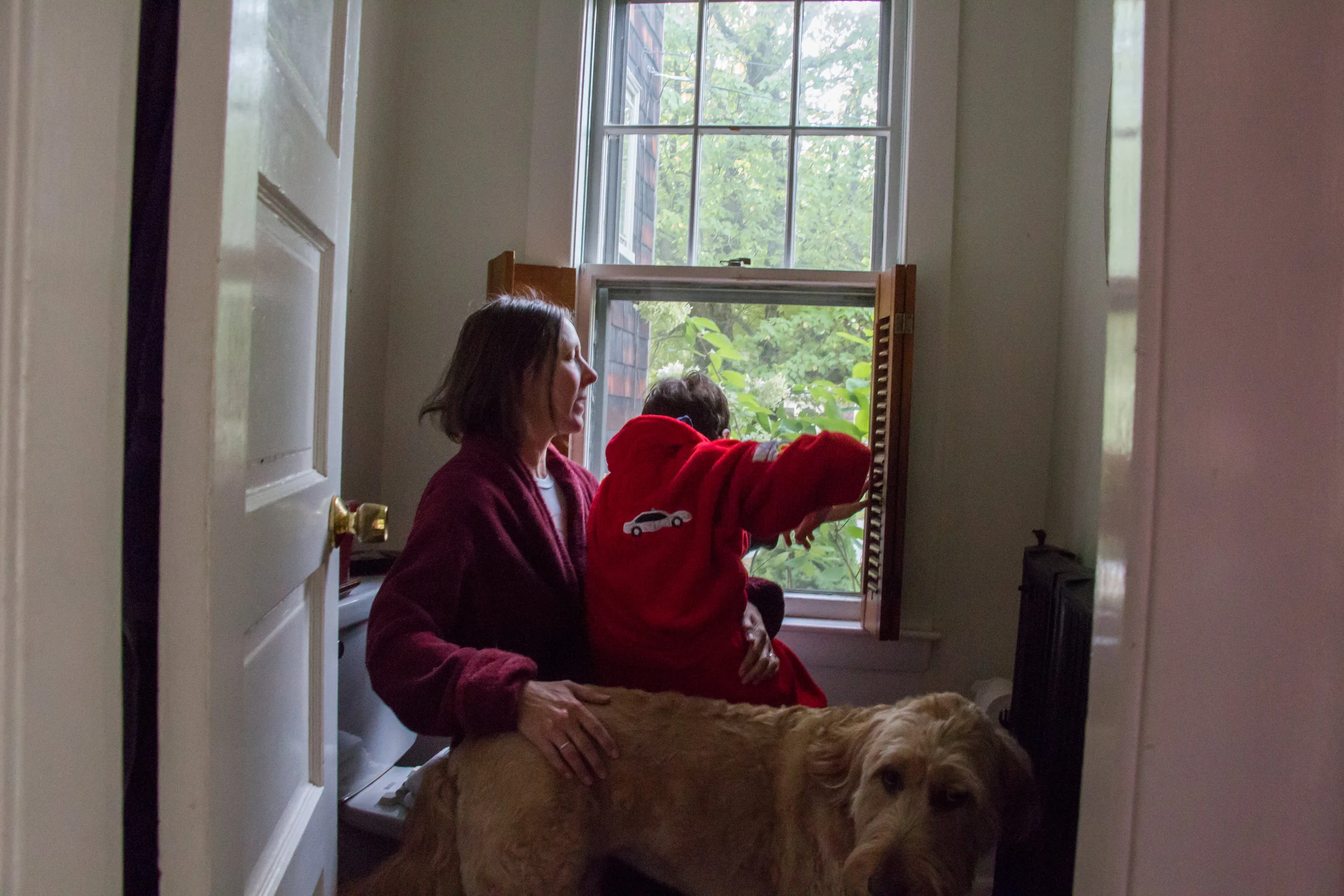 Christy Shake braces her son Calvin as he looks out the window of their home in Brunswick, Maine on September 30, 2017. Though Calvin can walk on his own now, his balance and vision are not good, and he can easily fall without Christy nearby to catch him. Much of their routine when he is home consists of her following him from room to room.