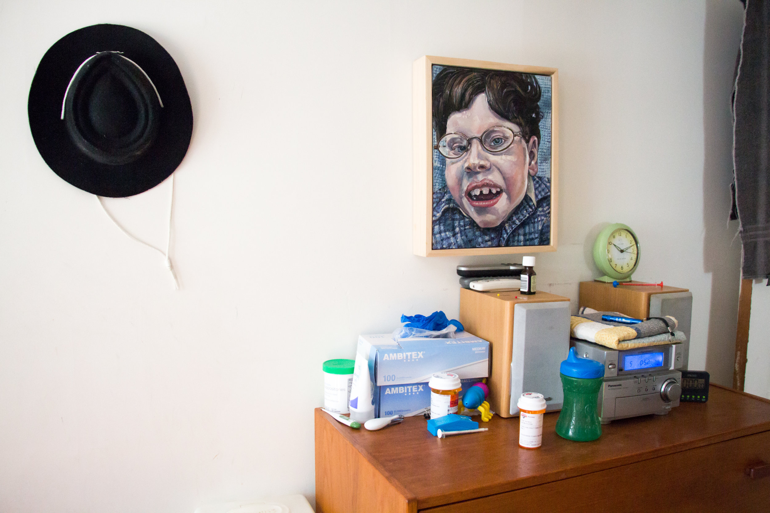  A portrait of Calvin hangs above a dresser covered with medications and medical supplies in his bedroom on September 30, 2017 in Brunswick, Maine. Calvin doesn't sleep very well and wakes up several times a night. Christy gets up to soothe him, cove