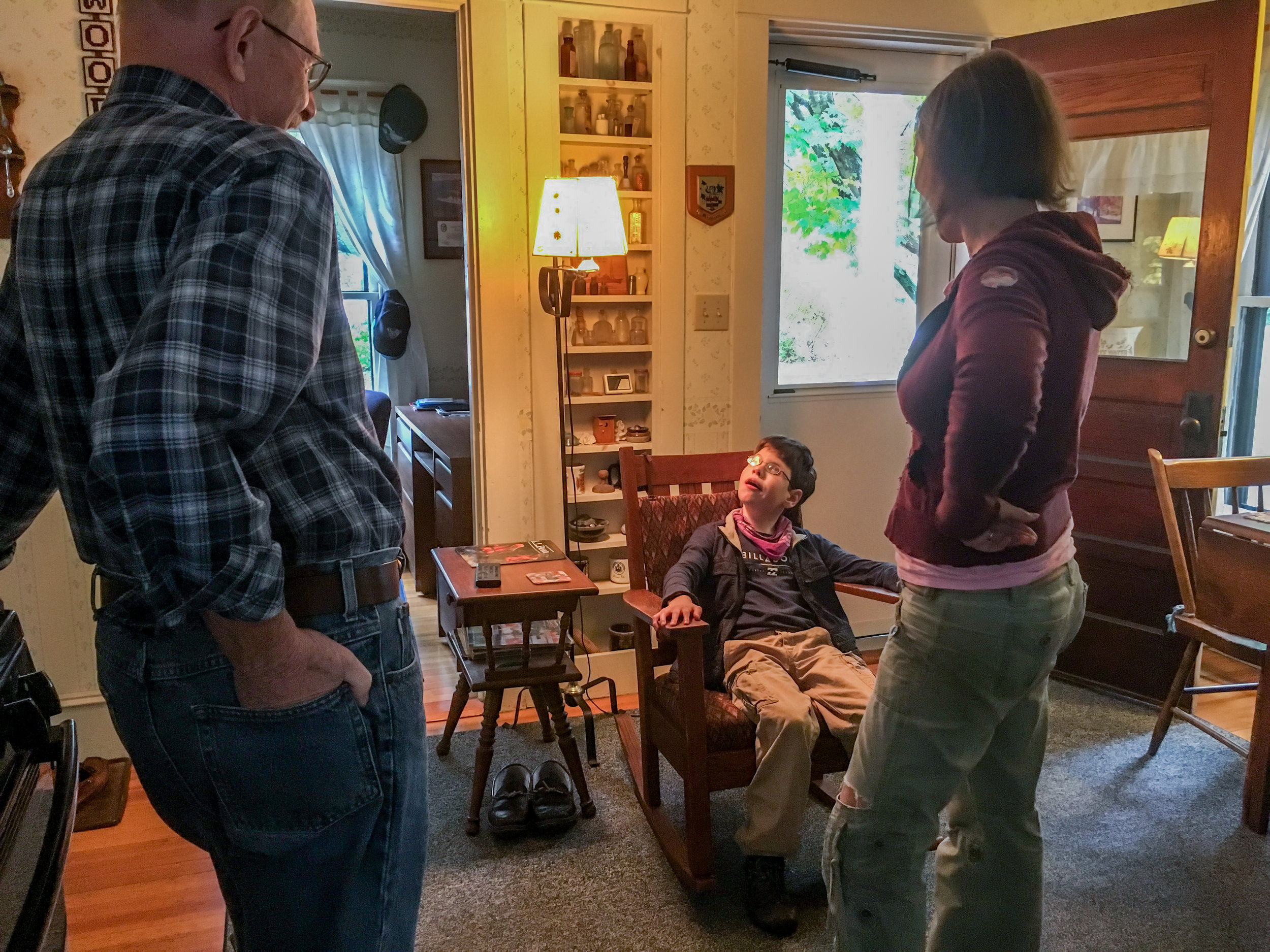  Calvin sits in a rocking chair eating a piece of chocolate at a neighbor's house on October 8, 2017 in Brunswick, Maine. Since reducing his benzo dose and adding cannabis to his treatment routine, Christy says Calvin has become calmer, more mobile, 