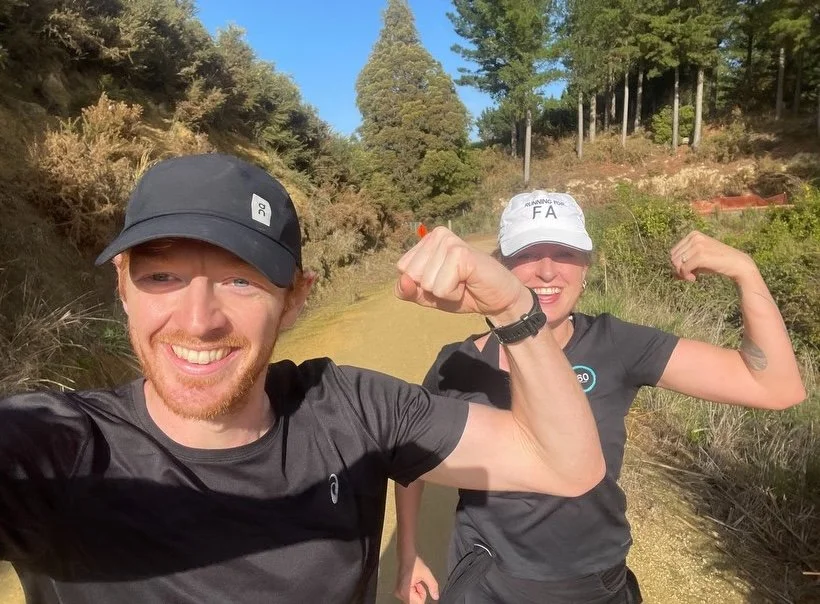 A man and a woman smiling while our for a run as part of a Friedreich Ataxia fundraiser. The woman is wearing a Running for FA hat.